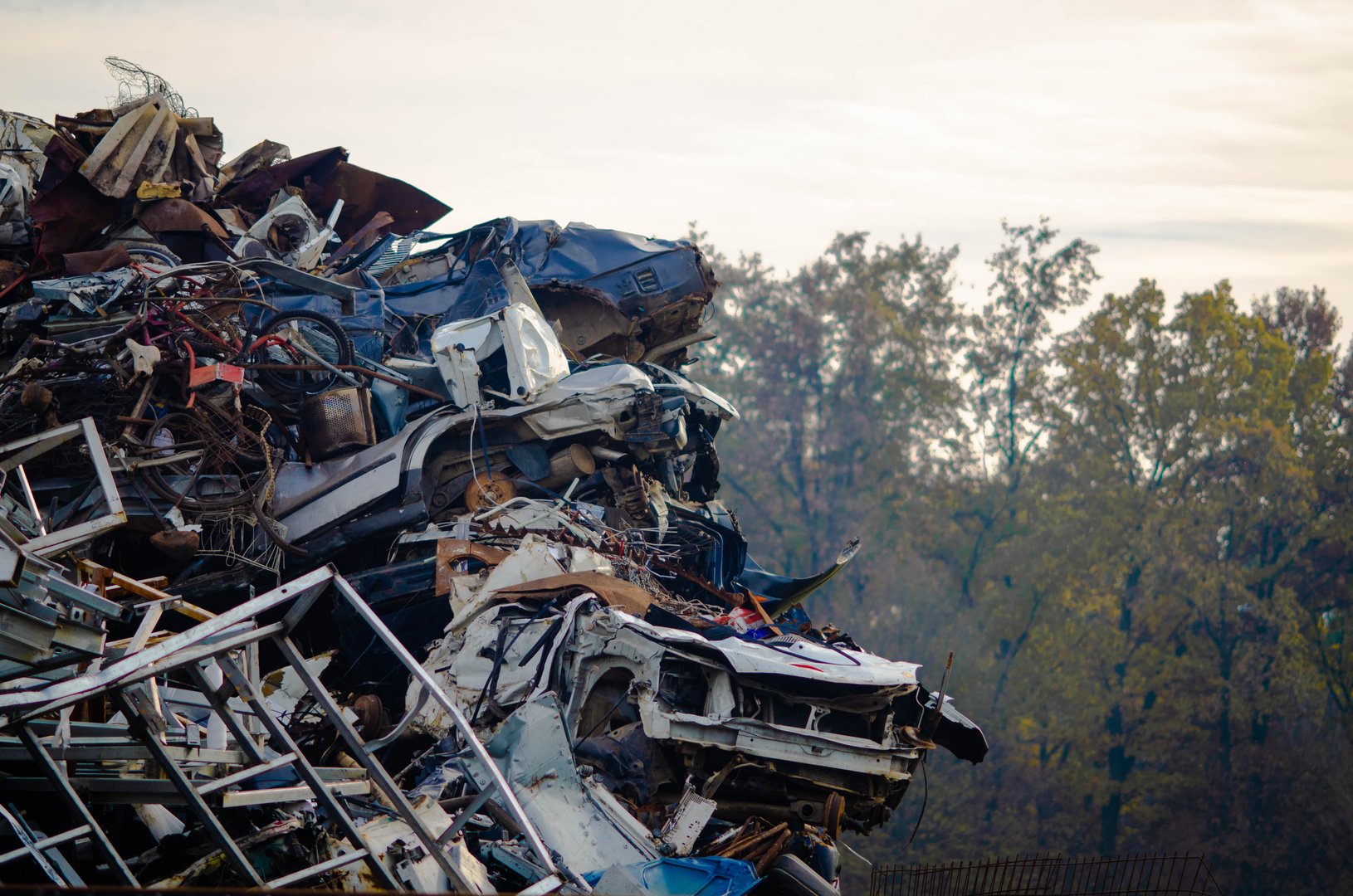 Old crushed cars stacked in a wrecking yard