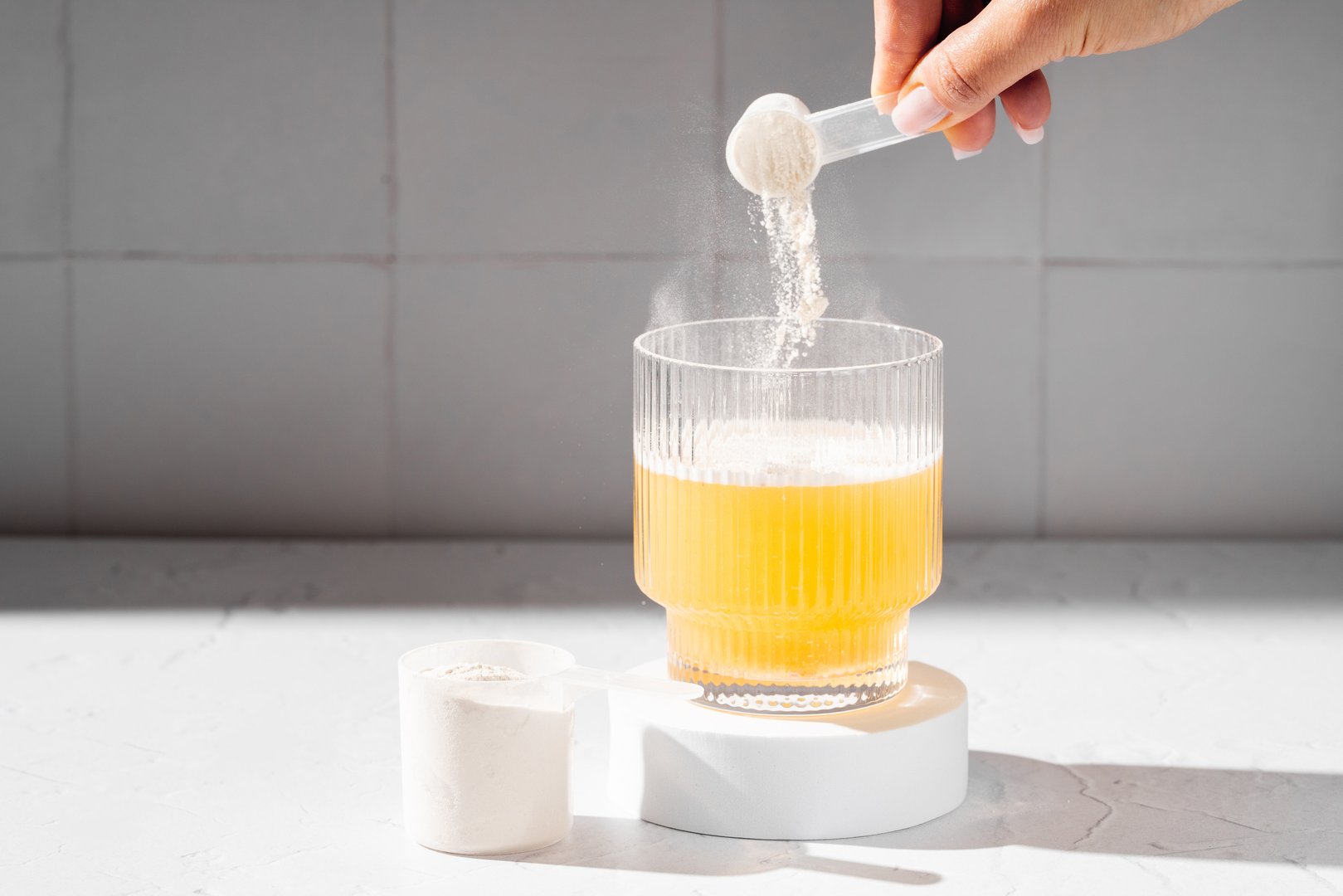 Collagen protein powder in a scoop. Glass of collagen beauty drink. Food supplement.