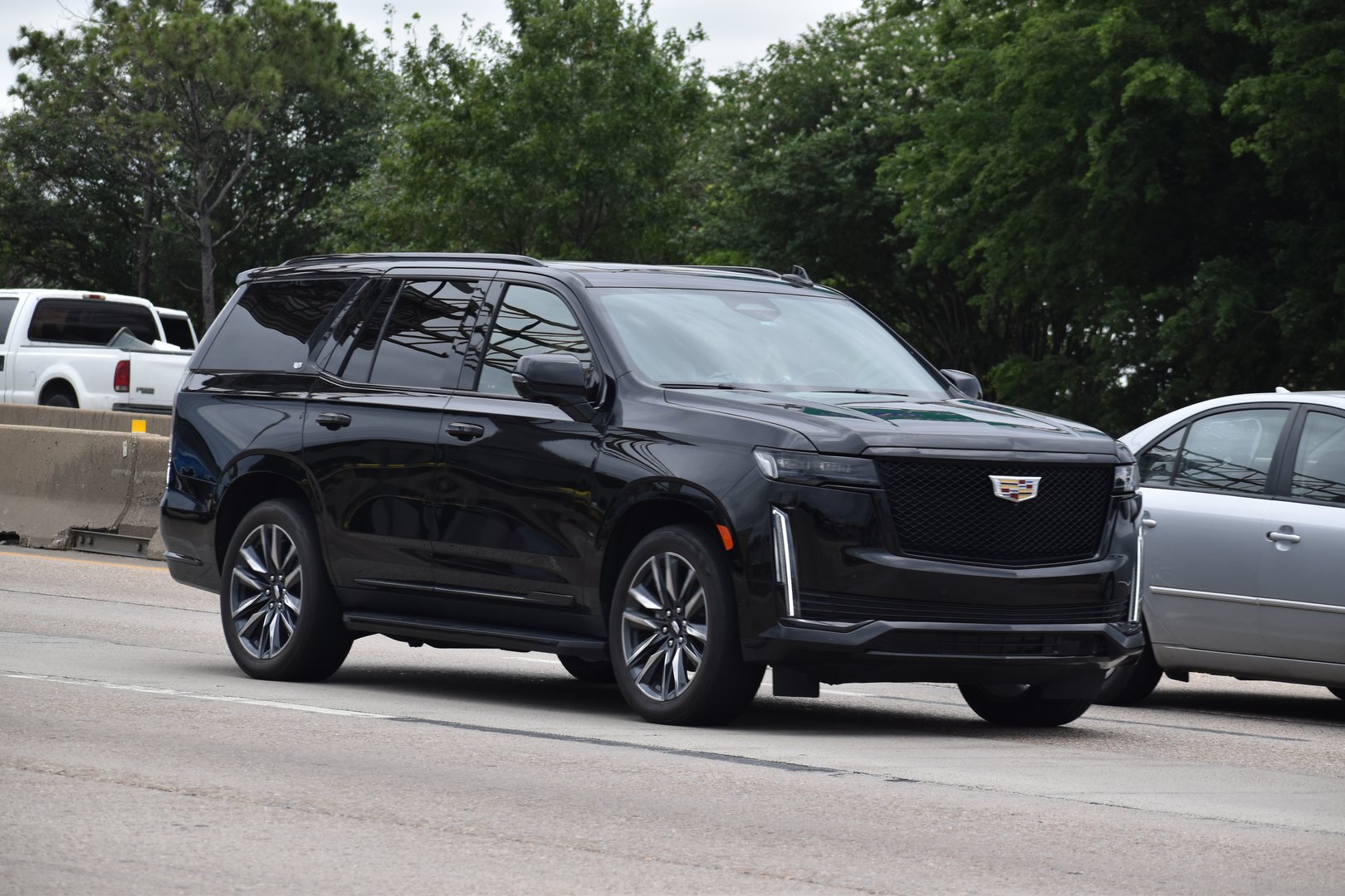 Houston, TX USA - 5/11/2024 - A portrait of a luxury black Cadilac Escalade ESV traveling down a highway in moderate traffic