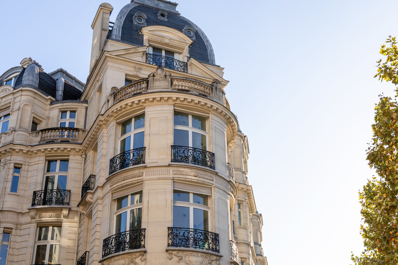 This stunning view highlights a classic Parisian building with ornate details and an elegant dome design