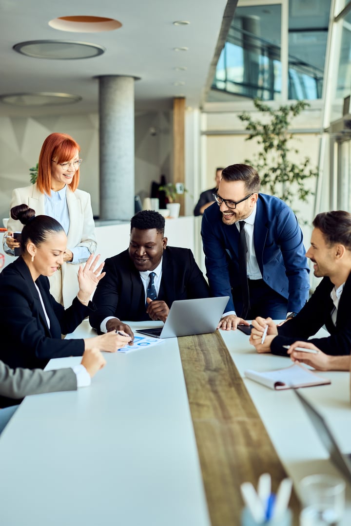 Business professionals collaborating on plans during a meeting in a stylish office setup.