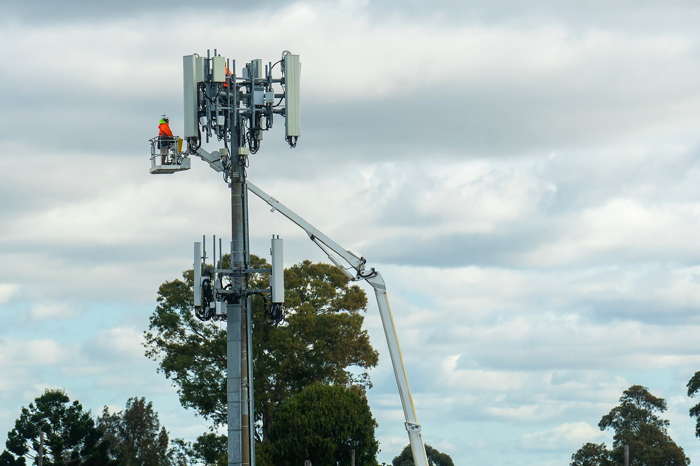 Special staff is working on the base station with transmitters 3G, 4G, 5G and antennas on the cell tower . Mobile telecommunication equipment