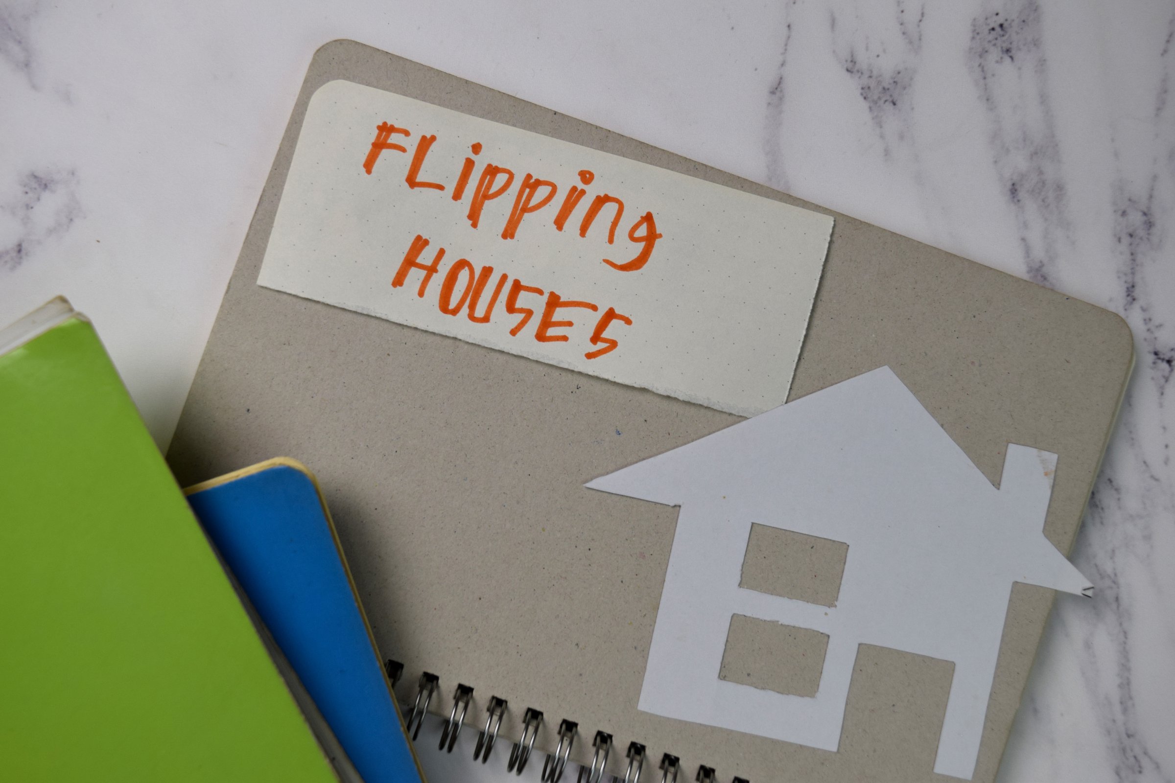 Flipping House text on sticky notes isolated on office desk.