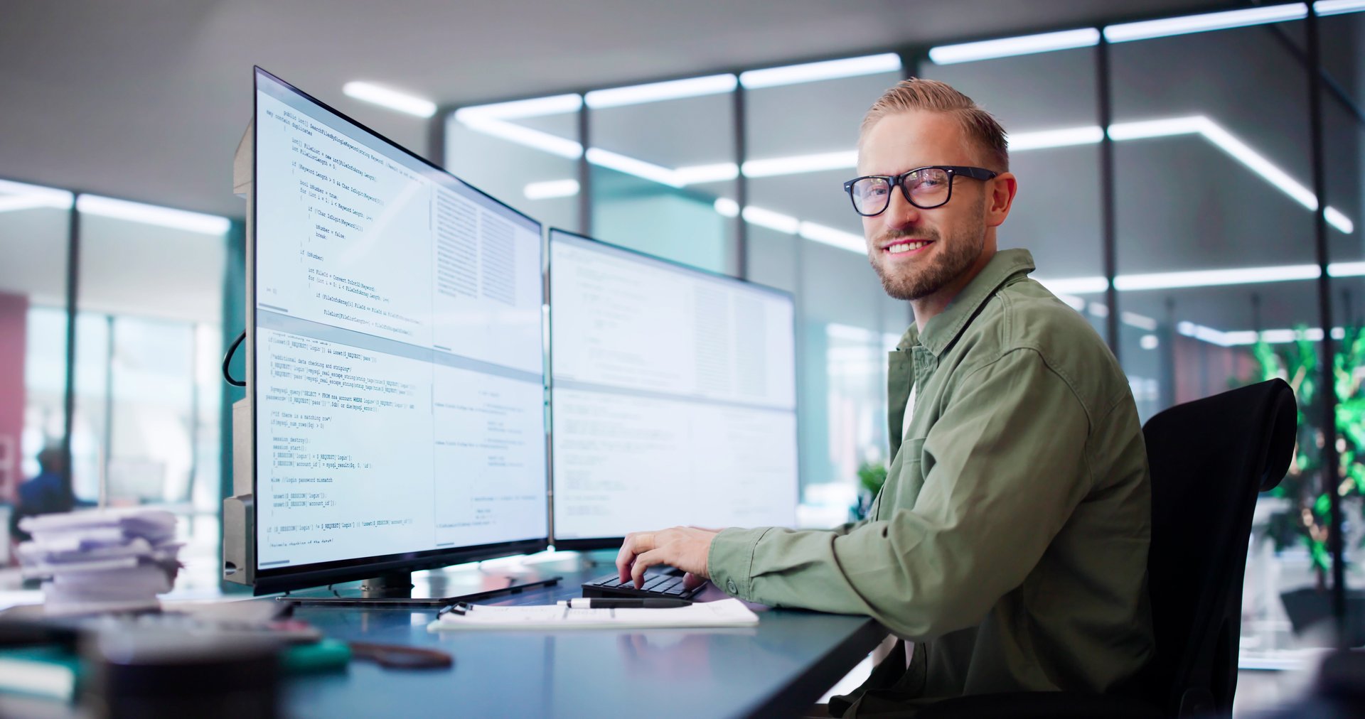 Computer Programmer Writing Program Code On Computer In Office