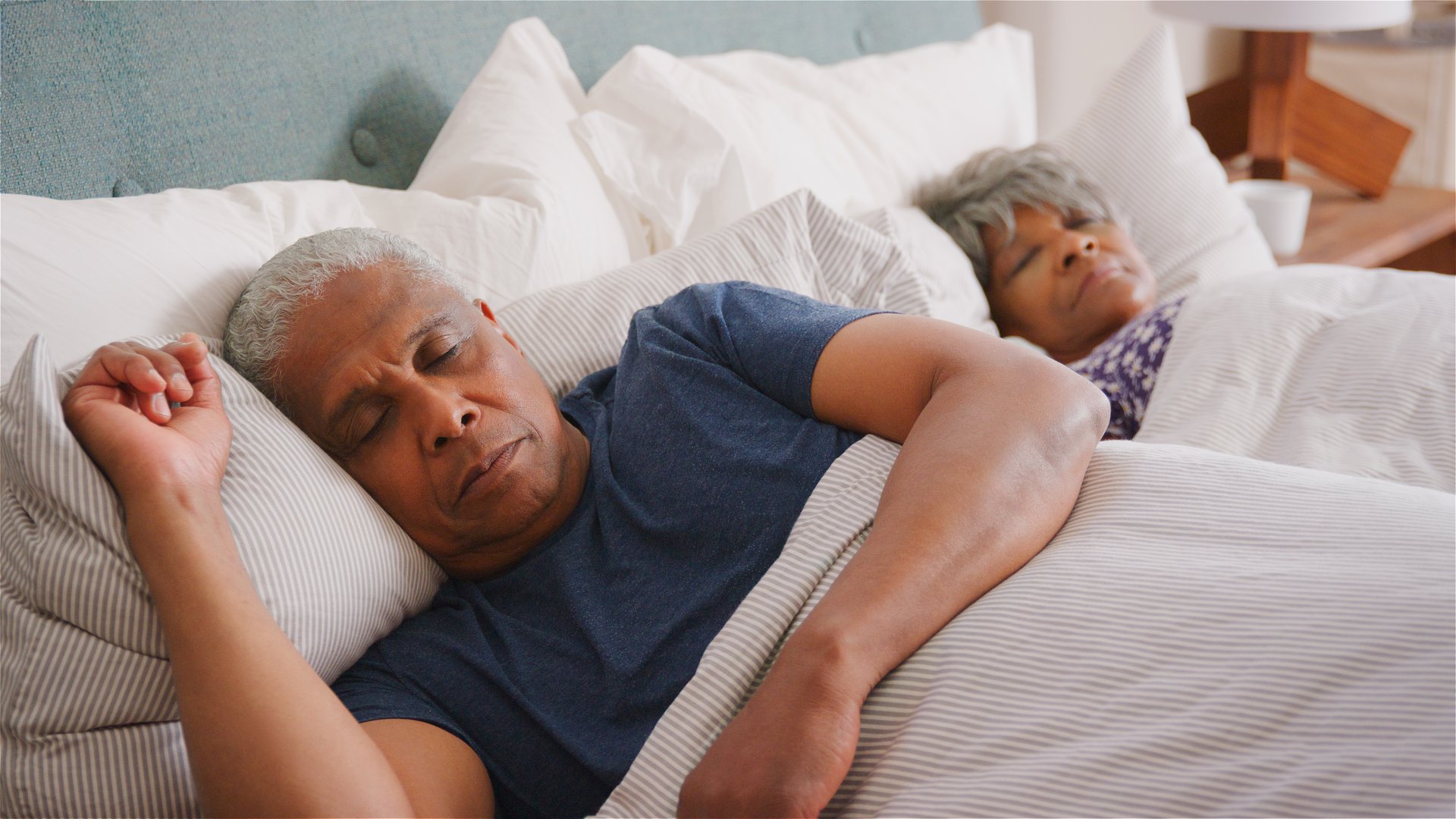 Senior Couple At Home Sleeping In Bed In Morning