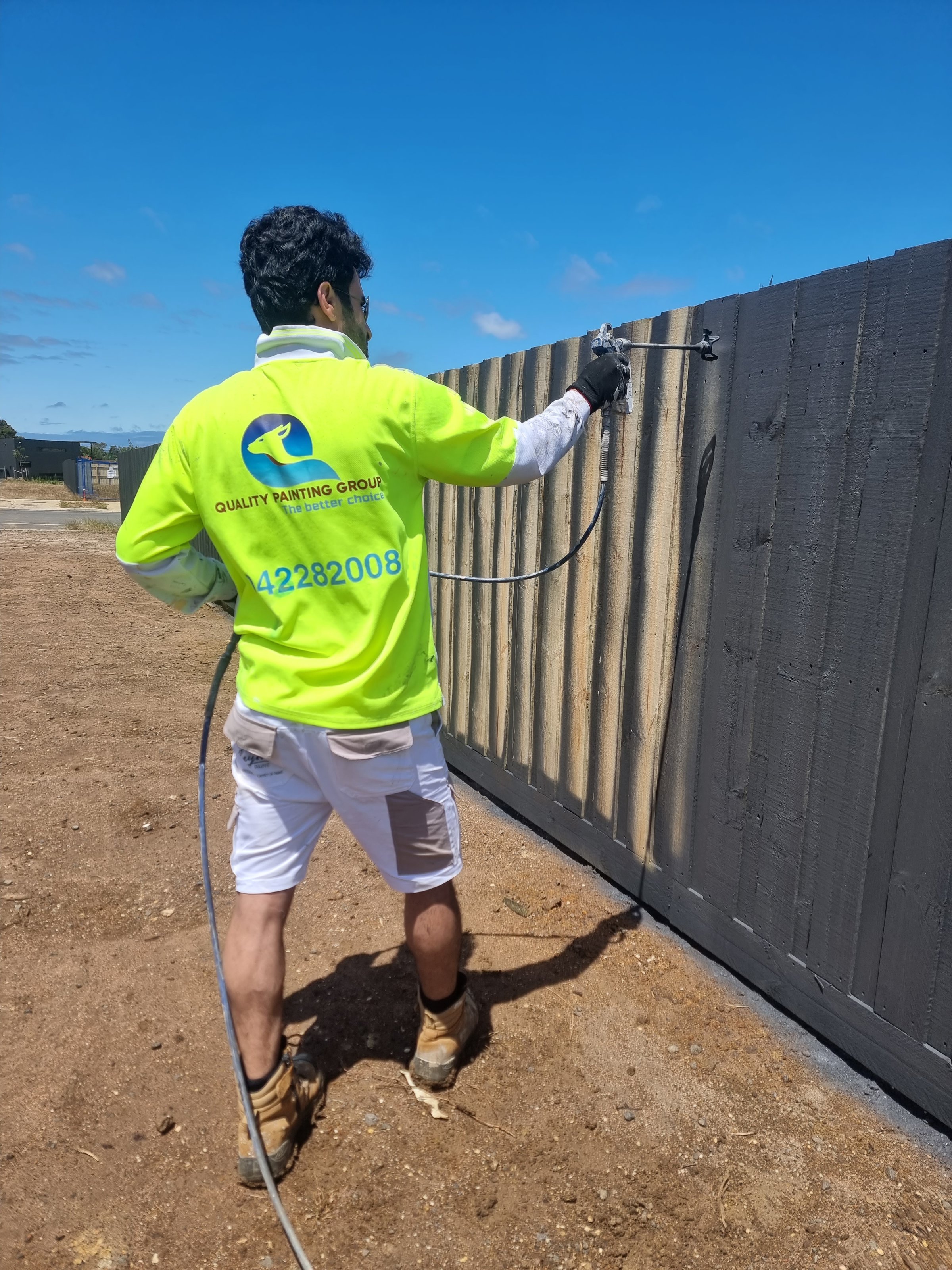 Quality Painting Group fence restoration mid-process - professional staining work November 2023