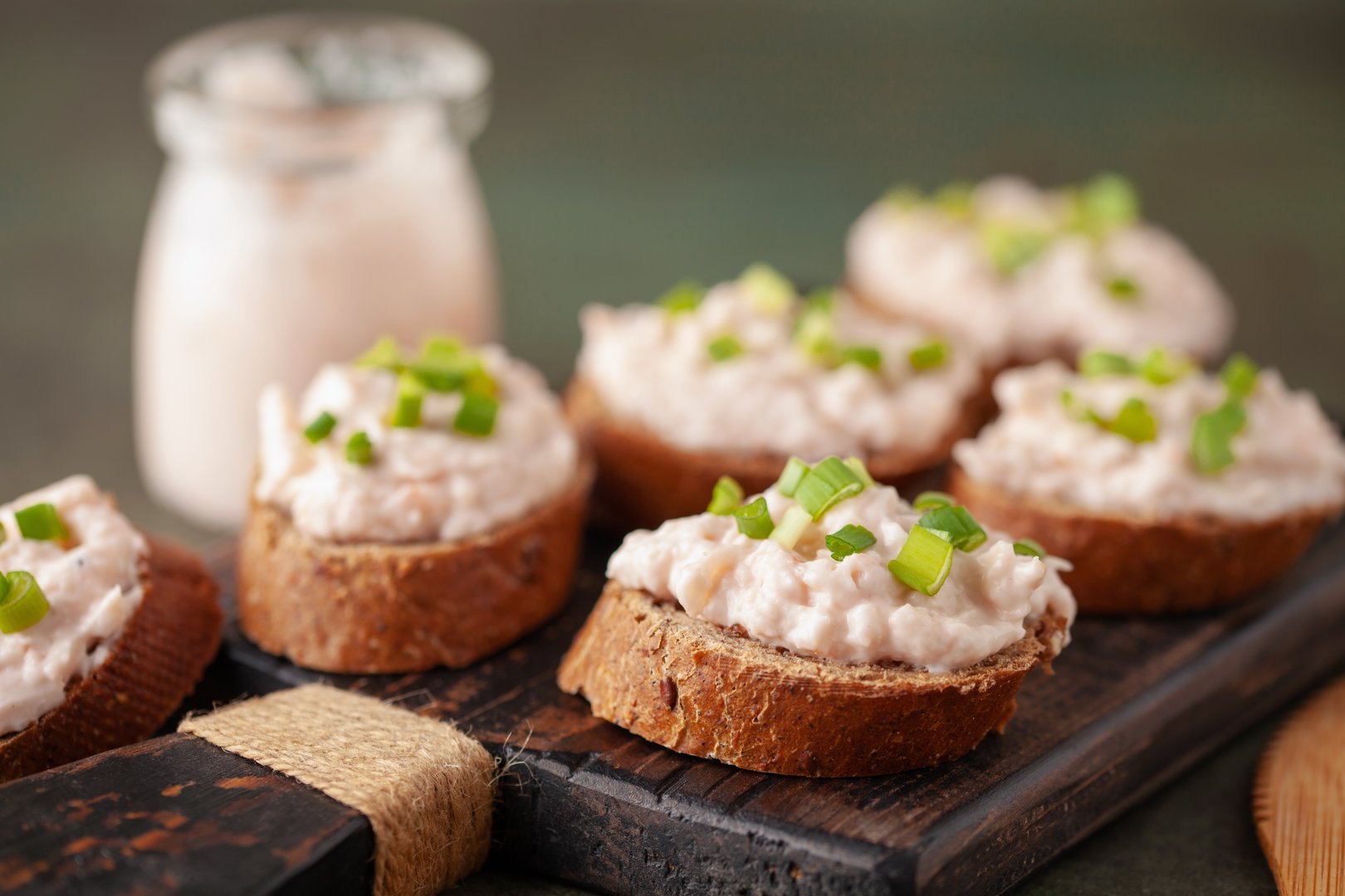 Tuna Pate Bruschetta with green onion, fish rillettes on wooden board