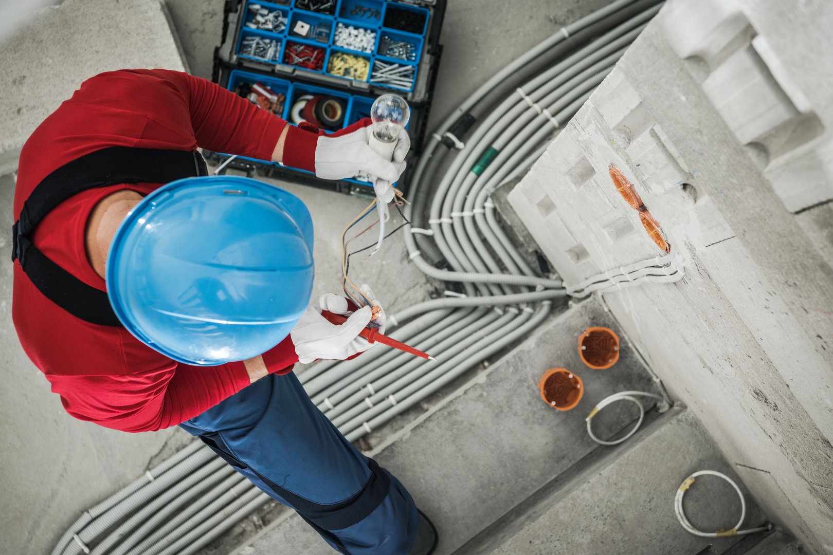 Top View of Professional Electrician Checking Wires While Performing Electrical Wiring Installation. Industrial Theme.