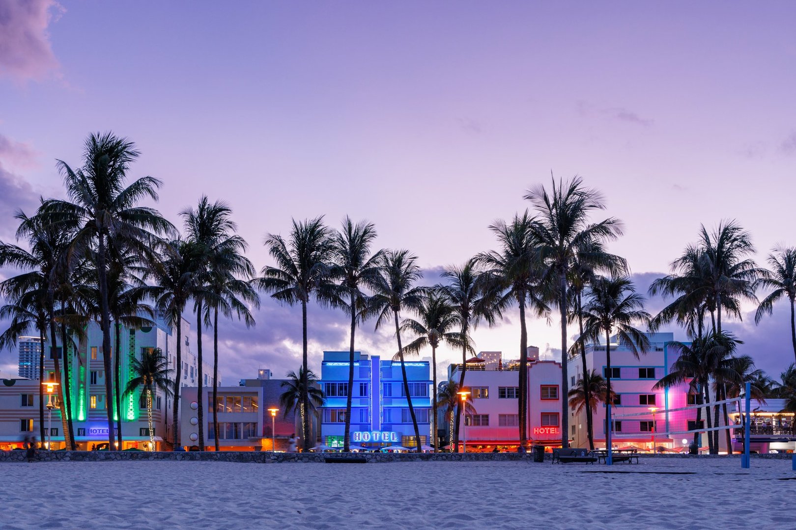 Colorful Art Deco hotels on Ocean Drive in Miami Beach glow under the warm hues of a vibrant sunset