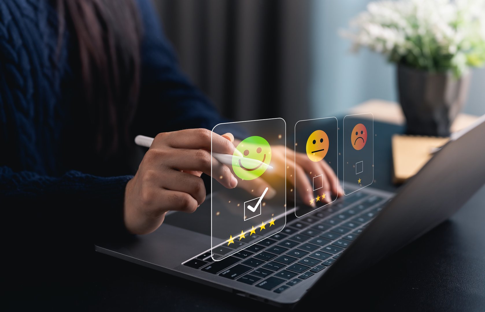 Close-up hand woman interacts with a laptop to express feedback using emotion icons and star ratings, reflecting the importance of customer satisfaction digital workplace.