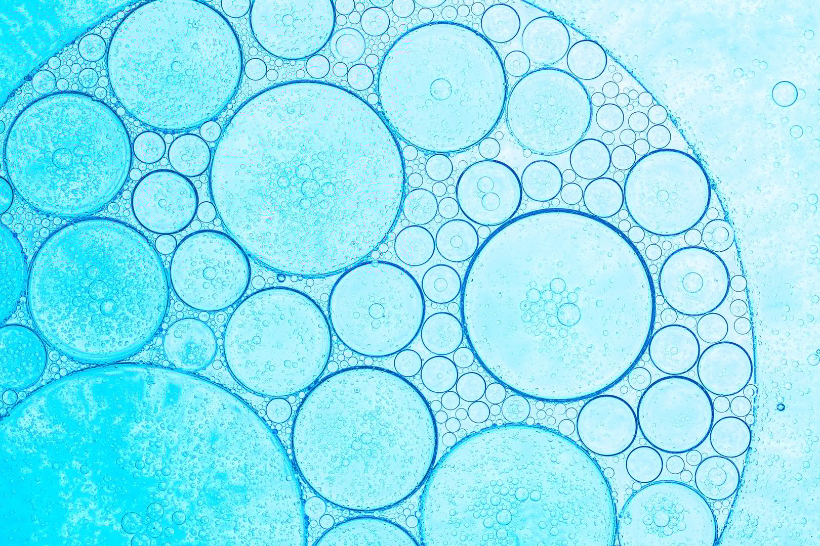 Macro blue bubble texture,Oil droplets creating bubbles,pattern and an art image with shadow effect caused by lighting and colour on light blue coloured background.