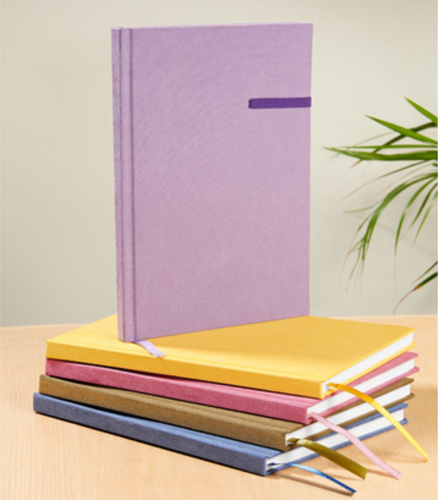 A stack of colorful hardcover notebooks with one standing upright; colors include purple, yellow, pink, brown, and blue.