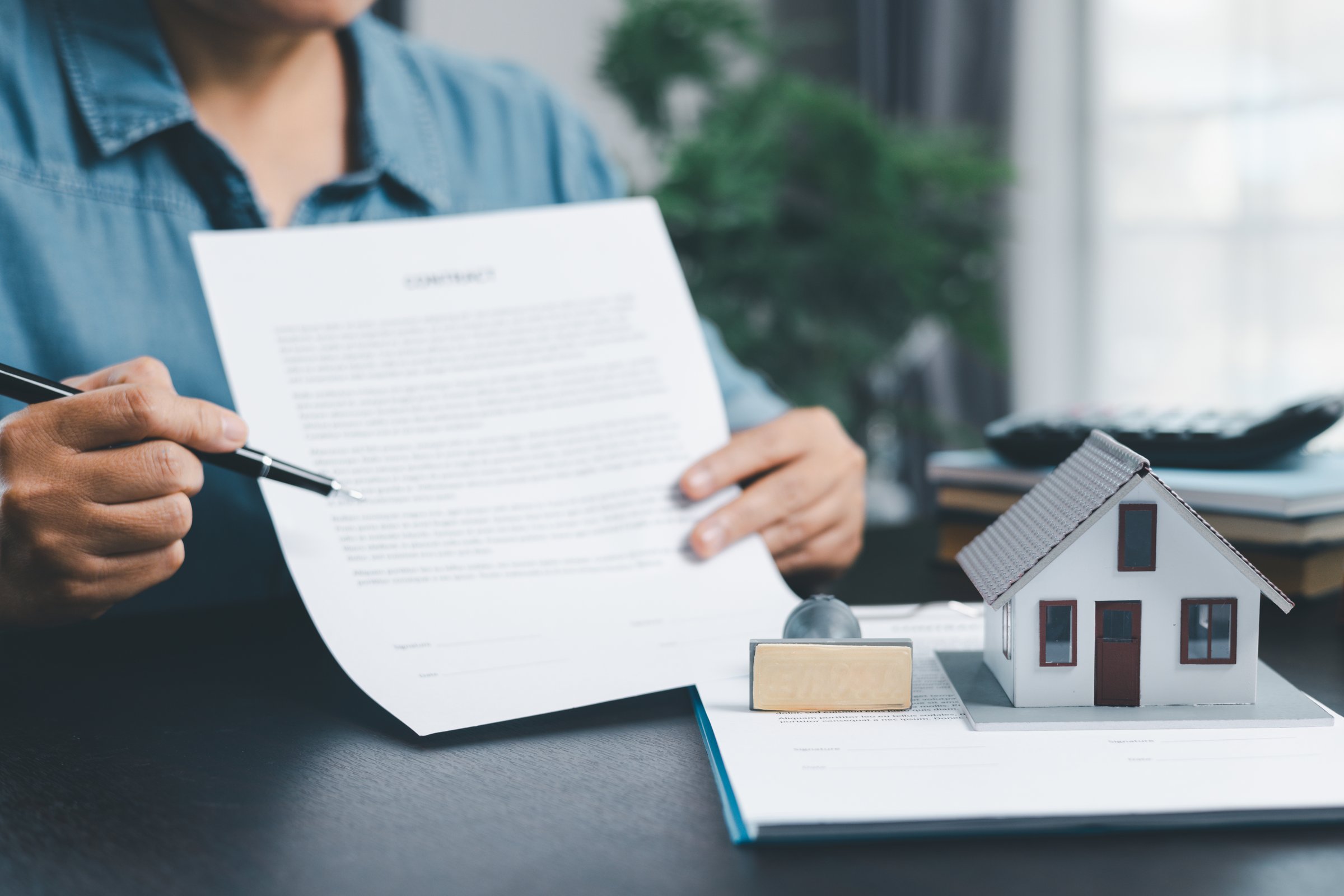 Female real estate broker presenting and advised to model home, building project detail in office, sign purchase sales application contract, agreements concerned mortgage loan offer and insurance.