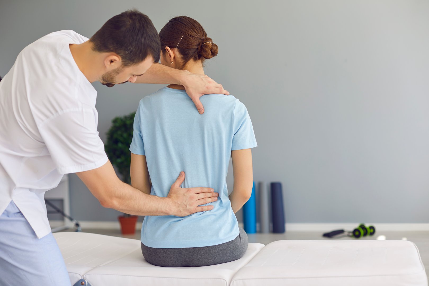 Professional osteopath or chiropractor fixing woman patients back muscles during rehabilitation theapy for backpain relief in manual therapy clinic. Chiropractor during work concept