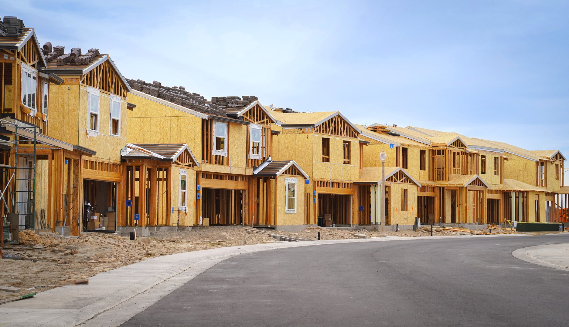 Single family homes  under construction on an empty street