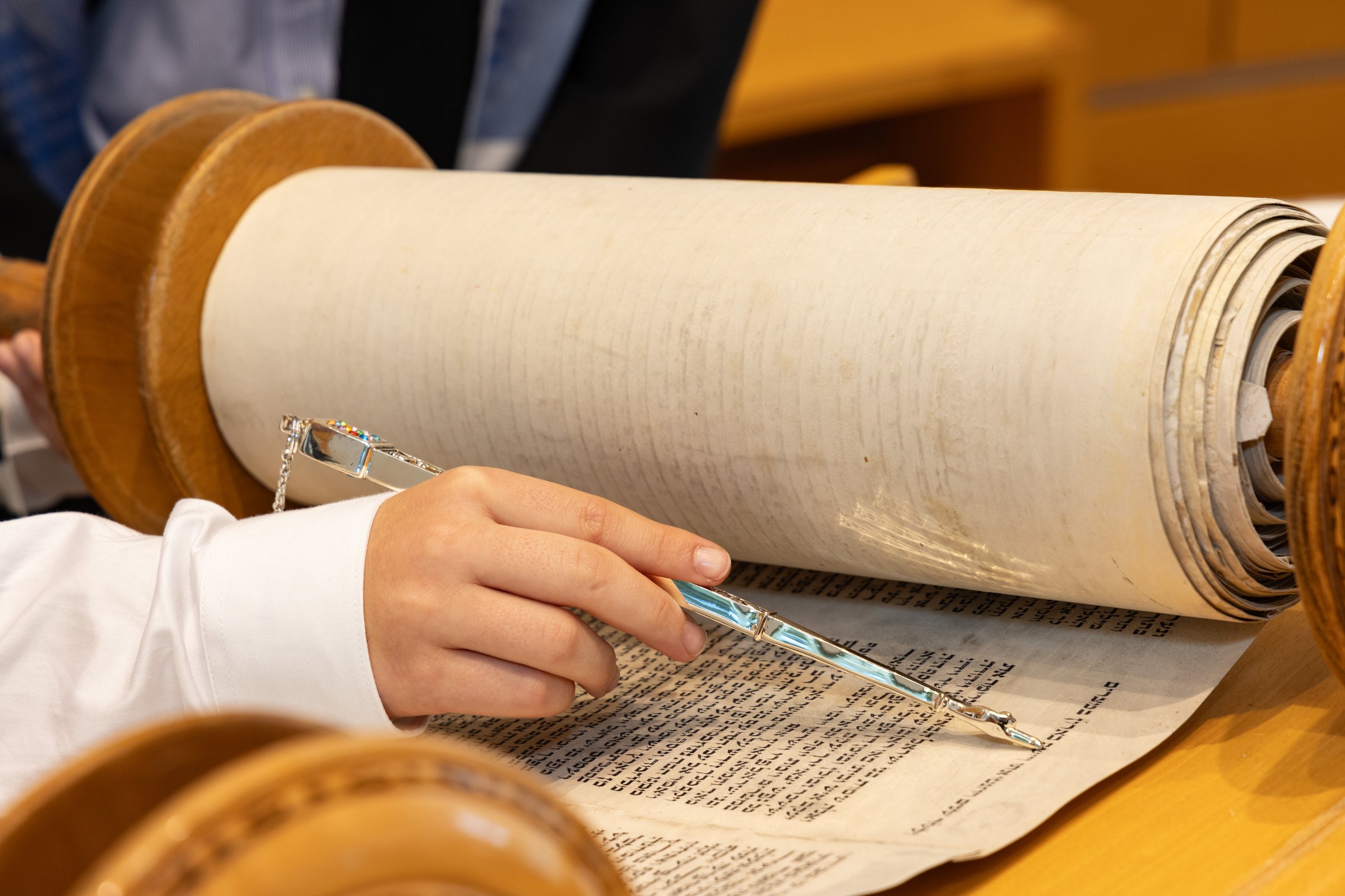 Hand of boy reading the Jewish Torah at Bar Mitzvah