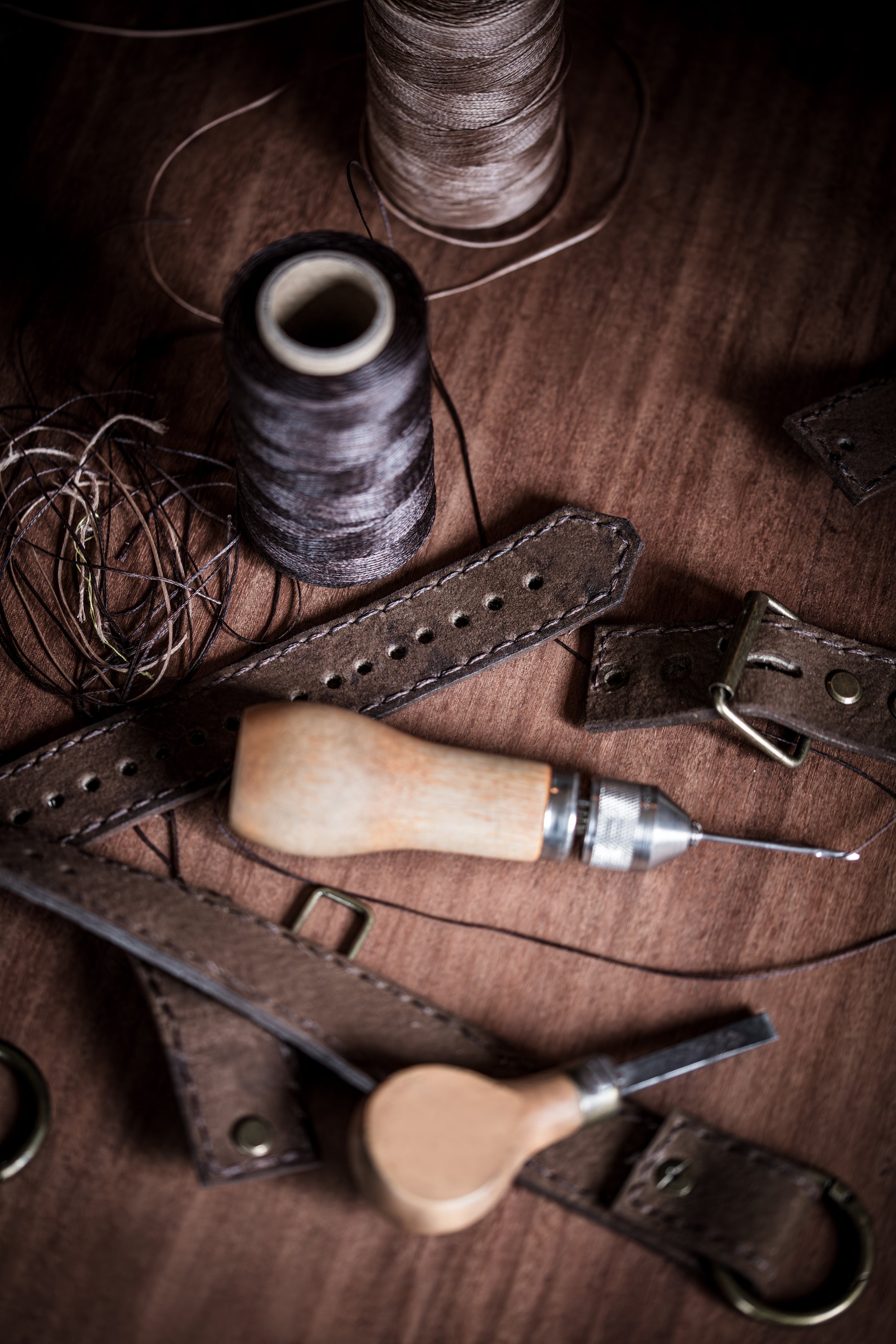 craft equipment and tools for working with leather or imitation leather. traditional craftsmanship in sewing leather such as belts or straps with buckles and brass rivets