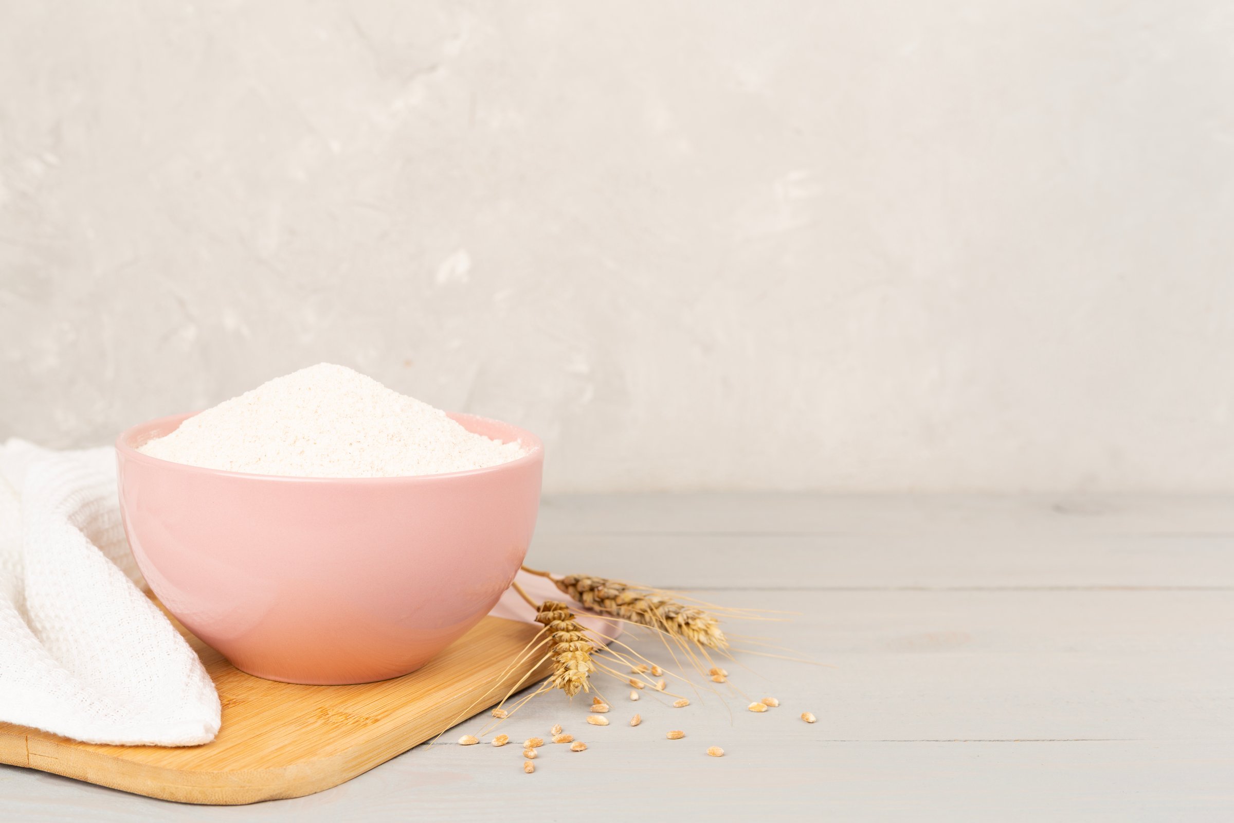 Bowl with spelt flour on concrete background