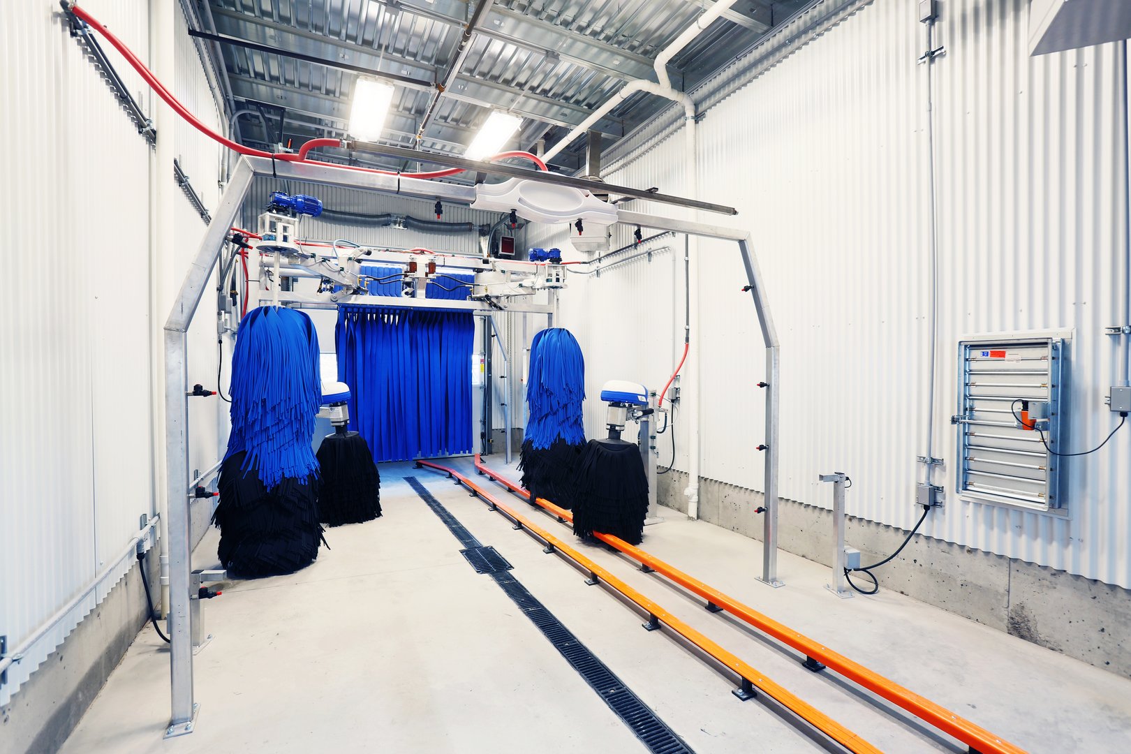Brushes and a chamois wall inside the tunnel of a new modern automatic car wash.