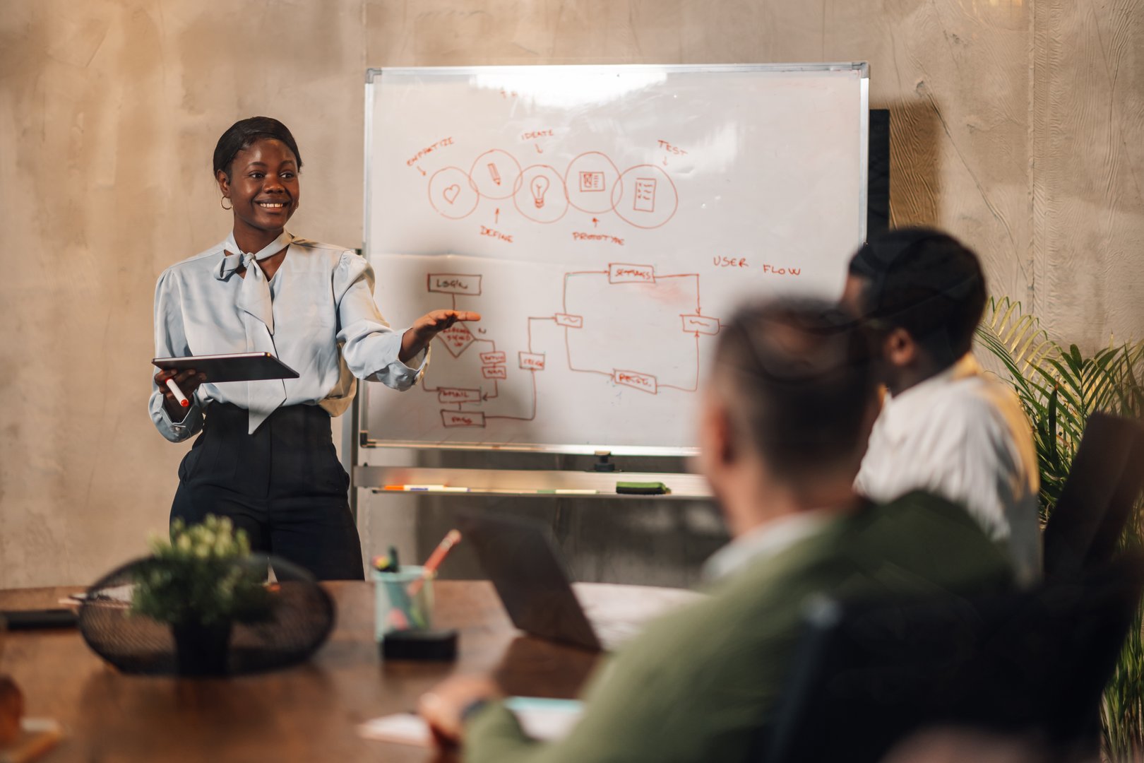 Professional woman giving presentation to business team in modern conference room