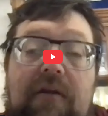 A person with glasses and a beard appears in a video thumbnail, featuring a play button symbol over the image.