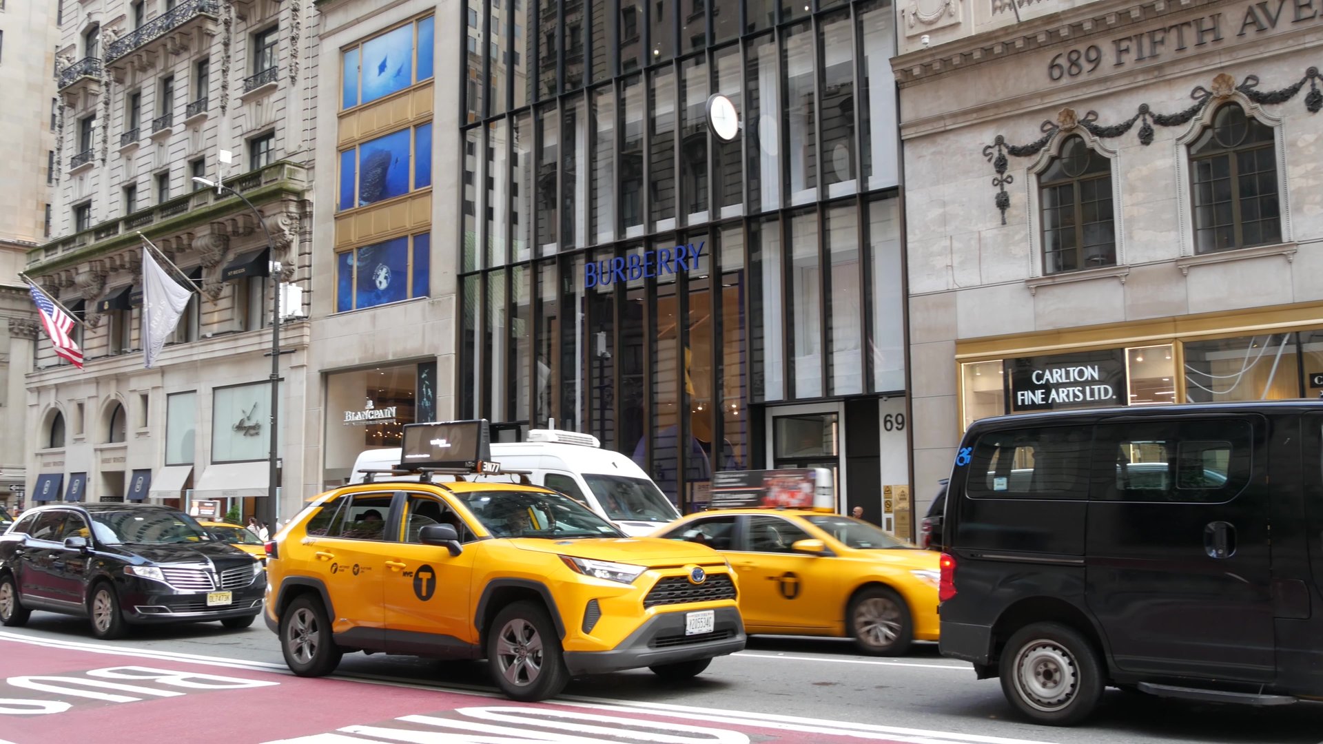 New York City, United States - 11 Sept 2023: Manhattan Midtown street, Fifth 5 avenue. American urban road car traffic. Yellow taxi cab in USA. People pedestrians. Boutique fashion stores for shopping