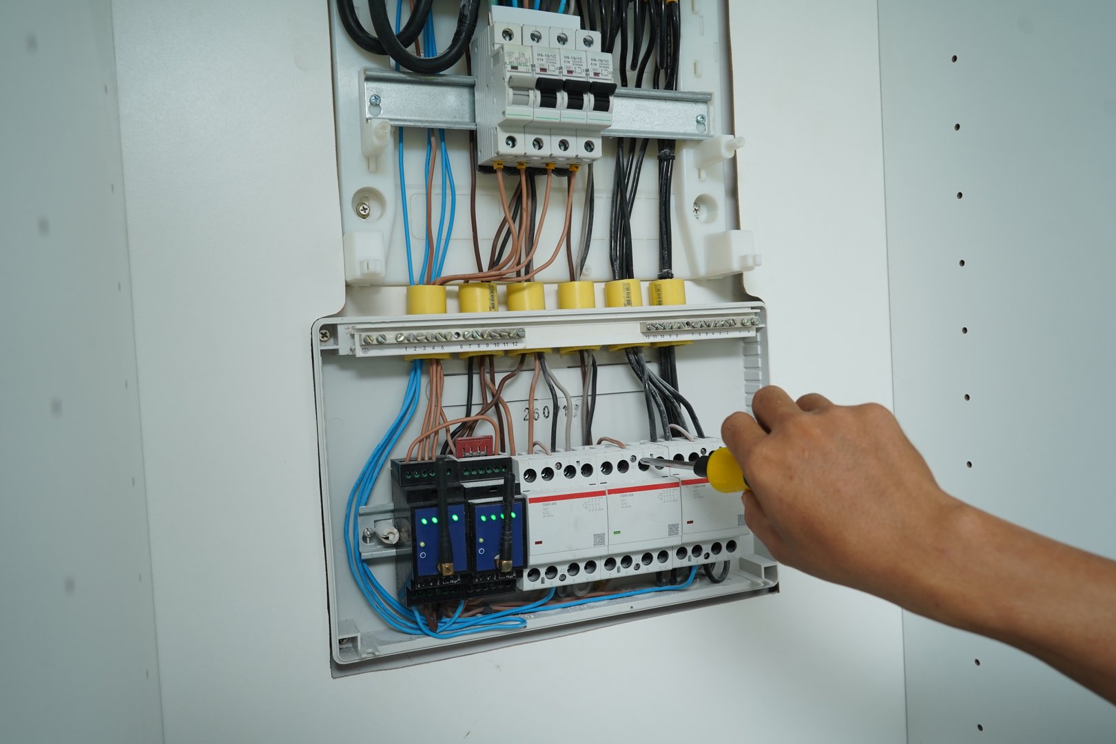 Electrician working checking a switchboard with fuses.