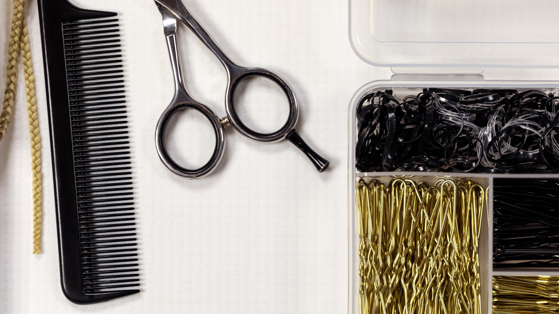 Set of hairdressing tools on white surface, scissors, comb, hairpins, flat lay, close-up. Barbershop, service, objects, detail, workplace, hair salon, professional occupation concept.