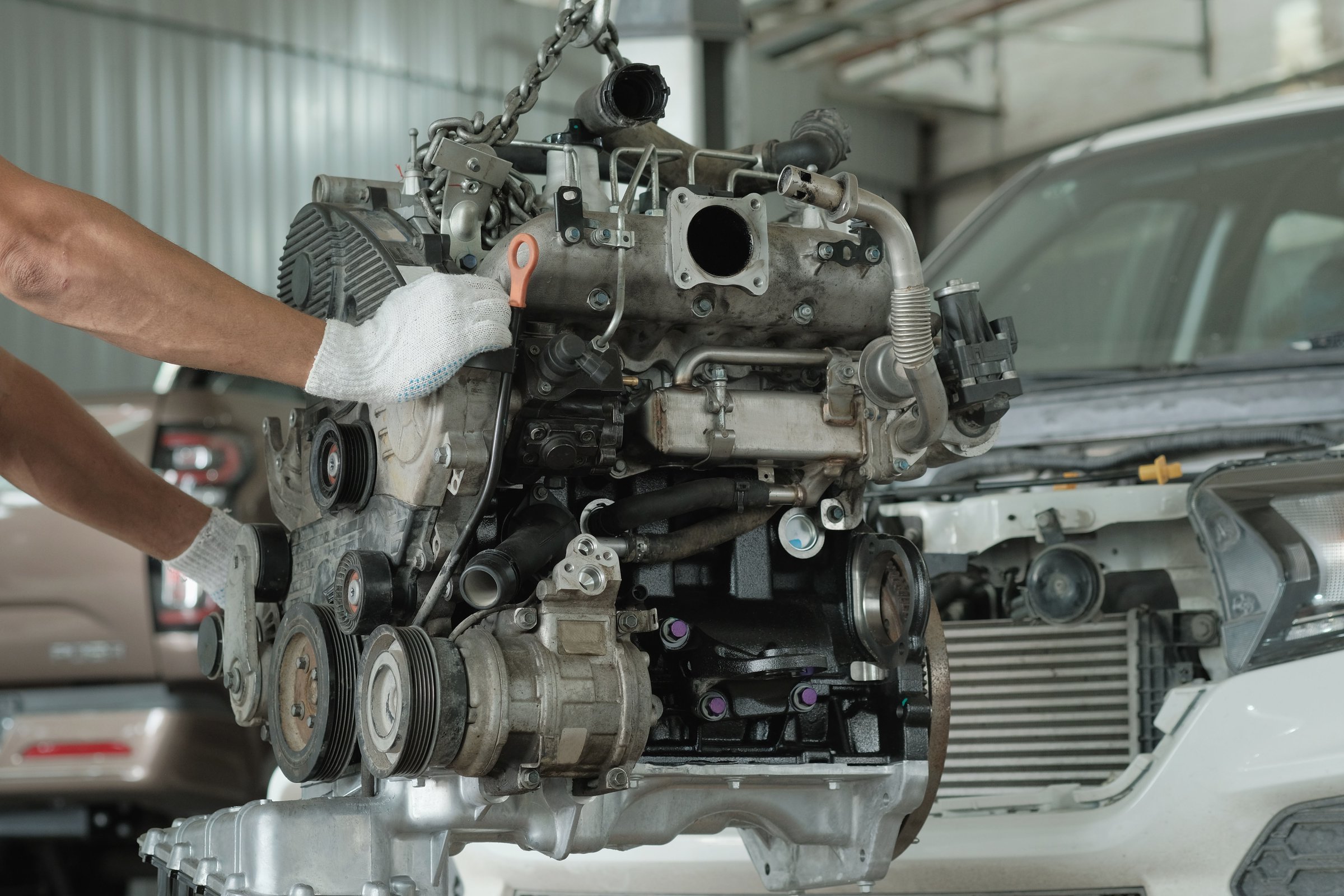 An auto mechanic prepares the repaired engine for installation.