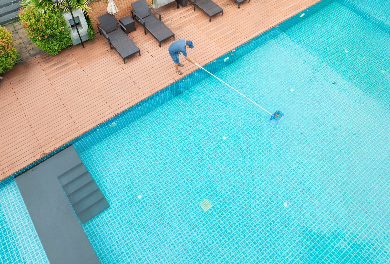Pool maintenance with scoop net to capturing the leaves on the surface of pool.