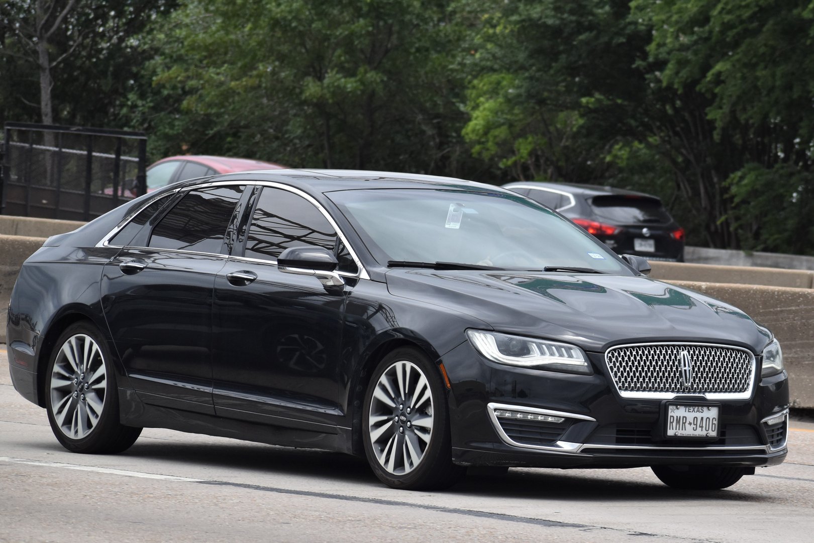 Houston, TX USA - 5/11/2024 - A portrait of a black Lincoln MKZ sedan traveling on the I-610 highway in moderate traffic