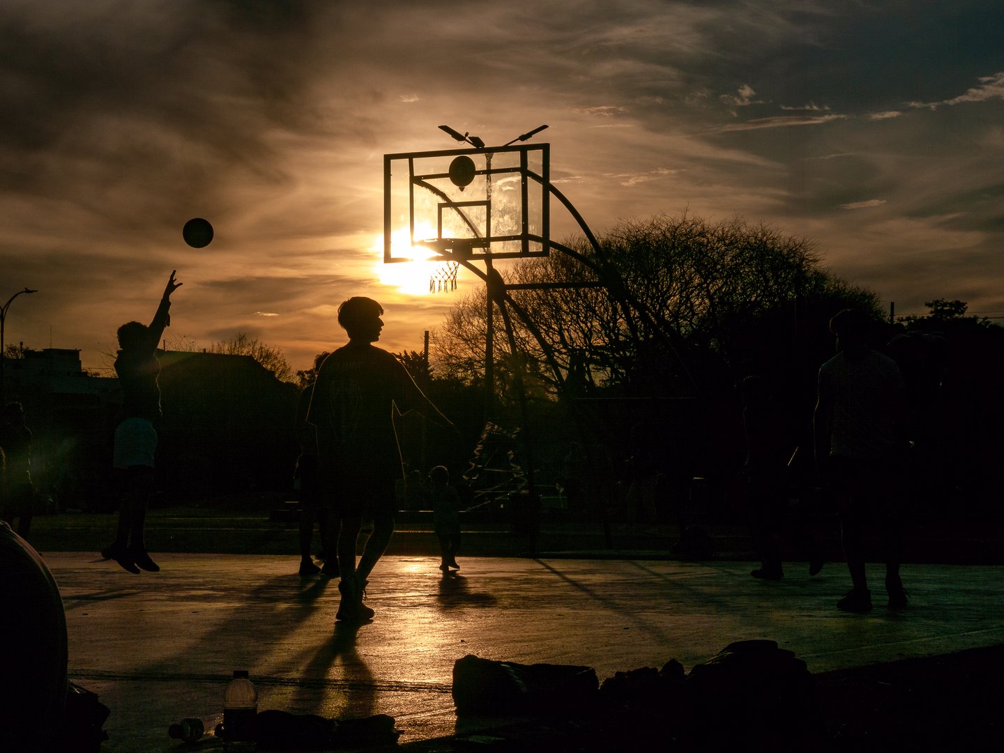A group of people playing basketball in a park