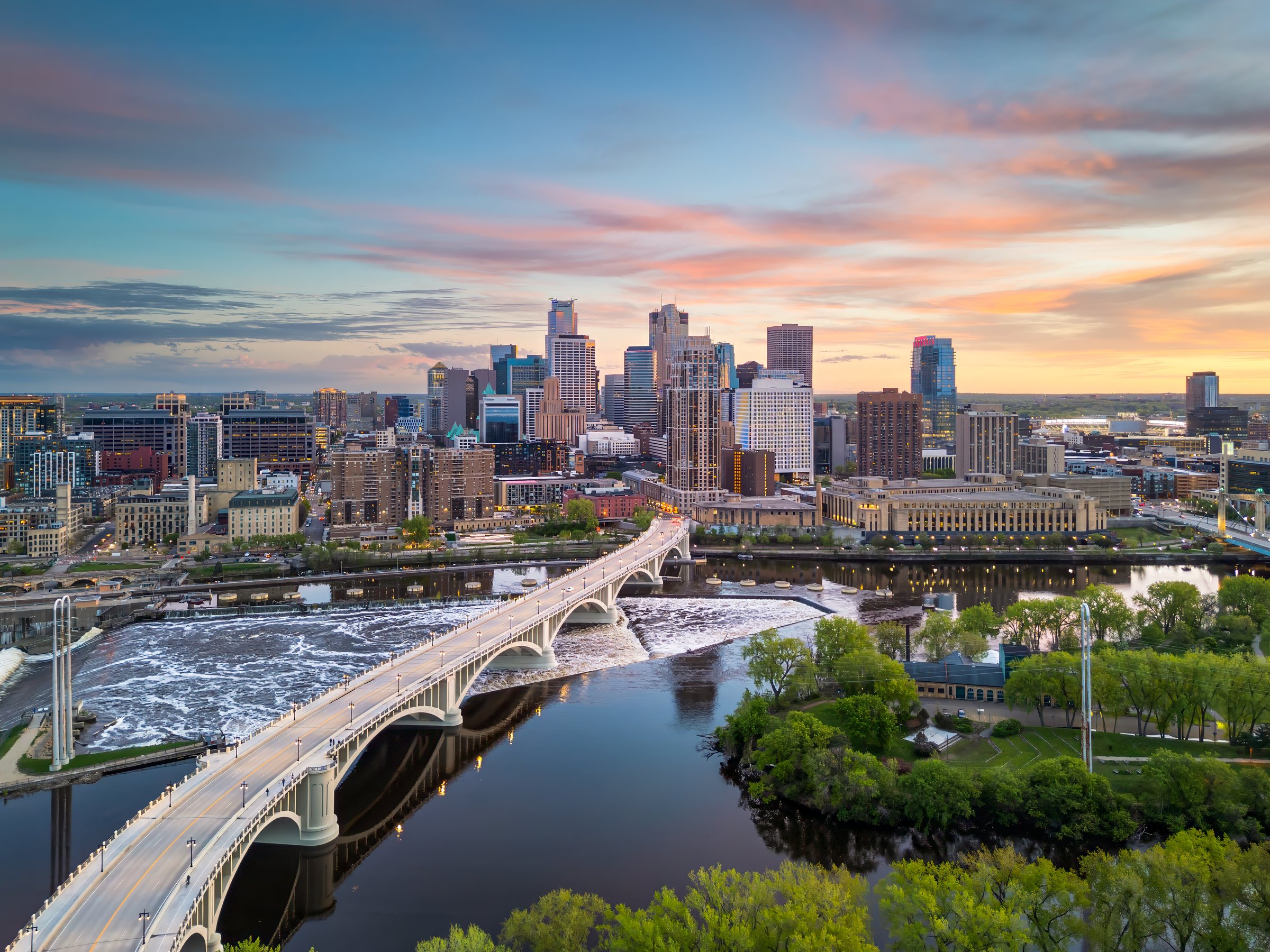 Minneapolis, Minnesota, USA downtown city skyline over the river at dusk.