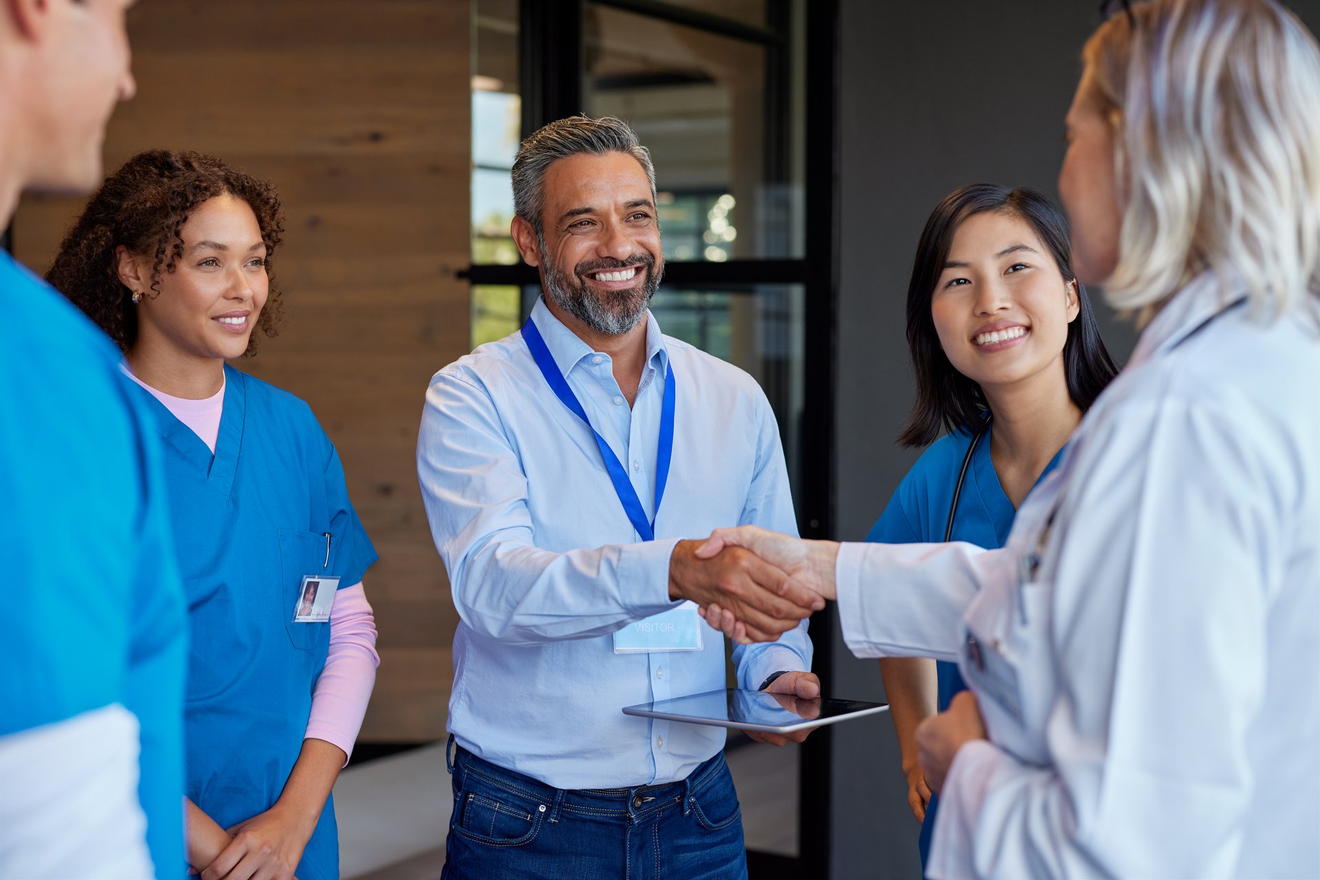 Healthcare professionals greeting pharmaceutical representative. Doctors and healthcare team discussing medical advancements with an indian representative. Medical staff collaborating on healthcare solutions and close a deal with a business handshake.