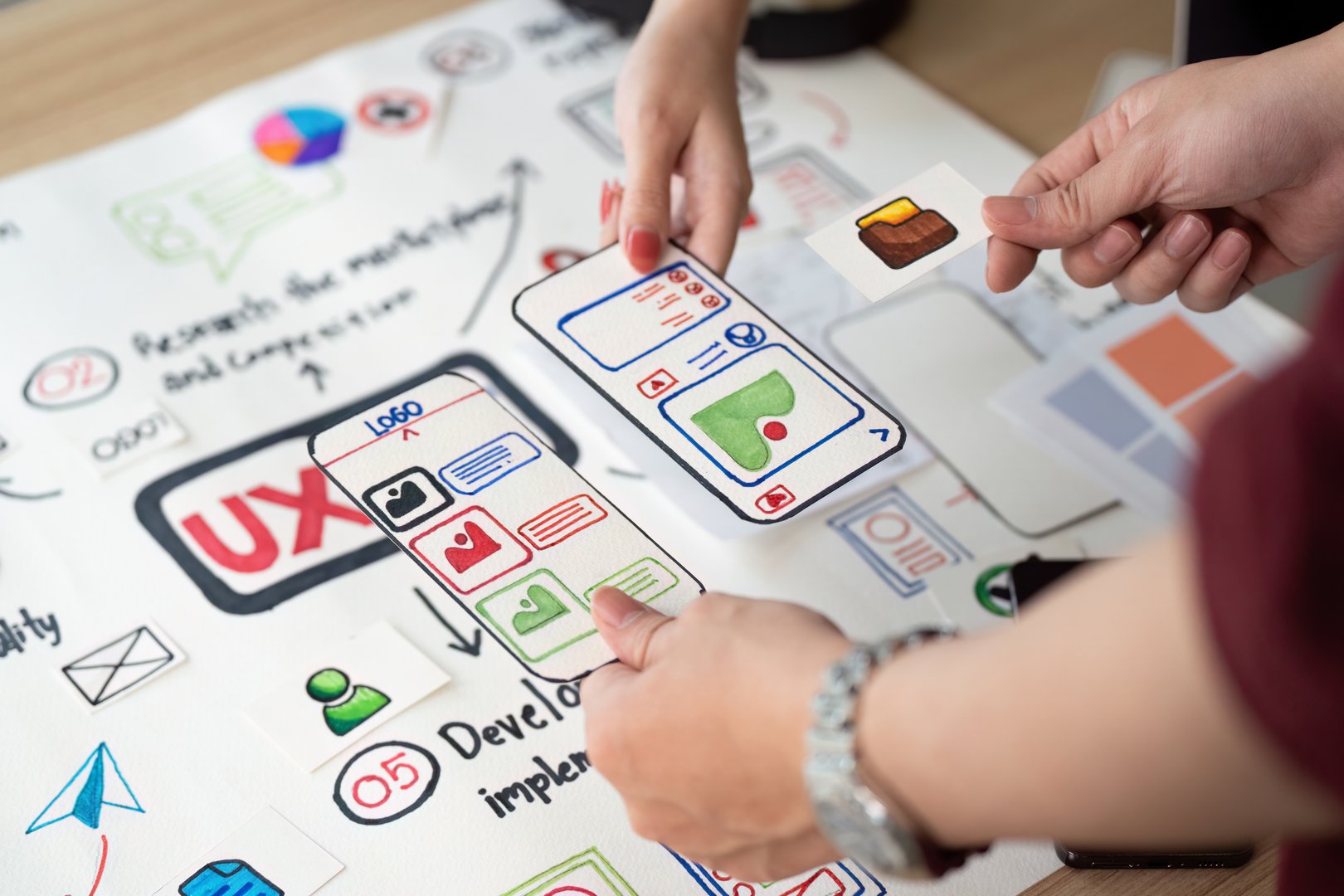 Hands-on collaboration in UX design, focusing on user interface elements and app features with visual aids.