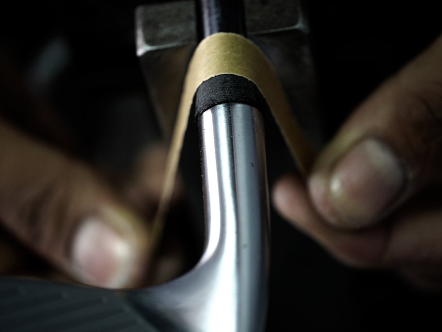 Clubmaker finishing the golf ferrule by hand with sand paper.