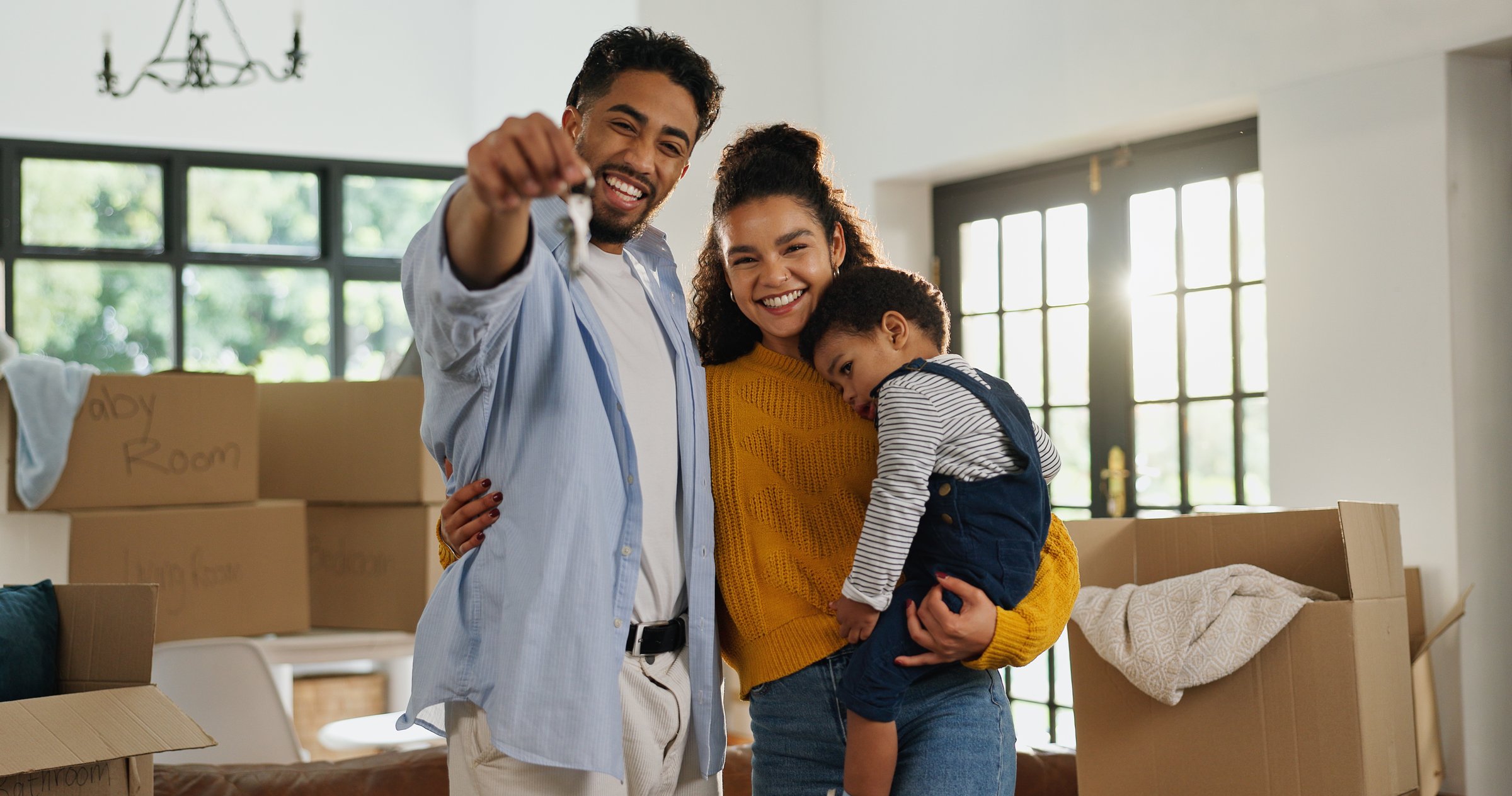 Young couple holding keys to their new home, smiling and celebrating their first home purchase with excitement and joy
