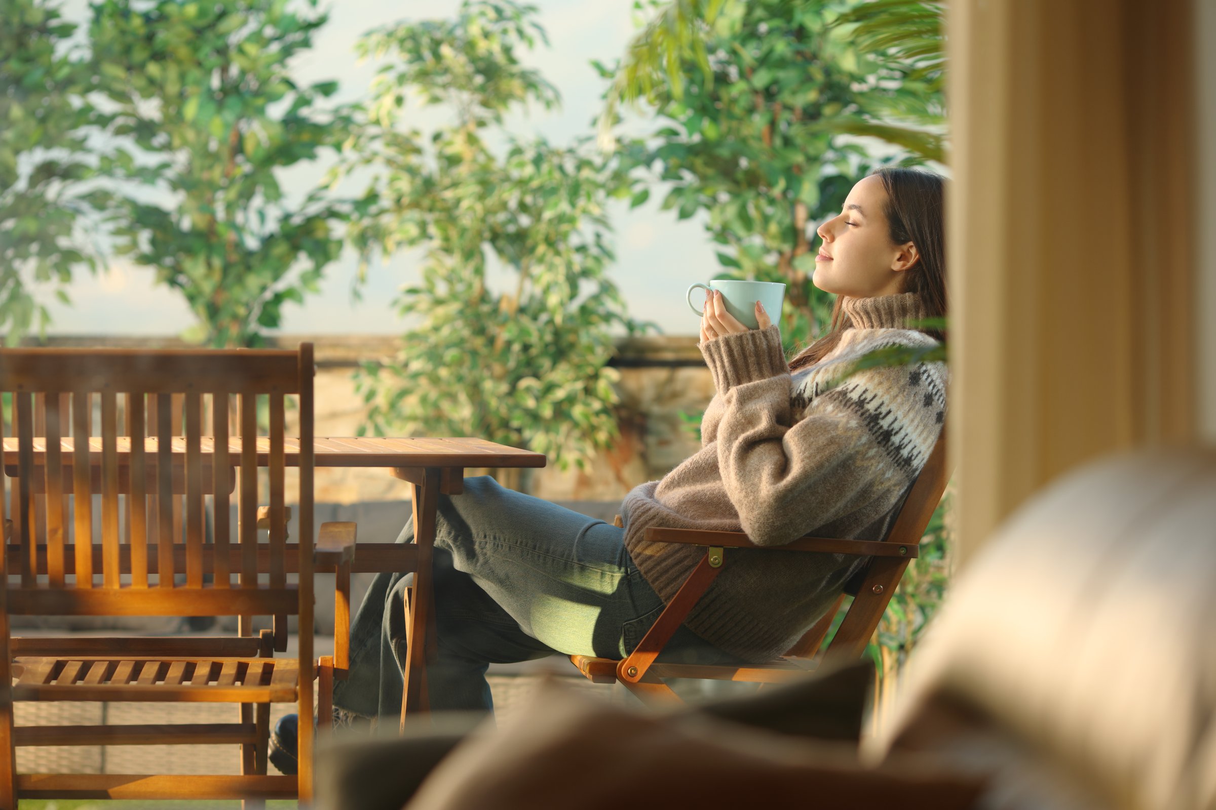 Woman in a house terrace drinking coffee and breathing