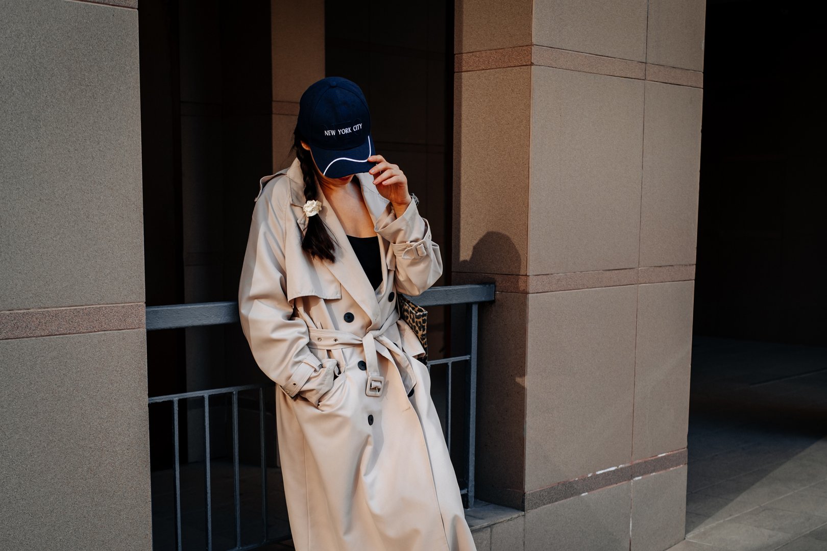 Street style casual fashion, young woman wearing stylish long beige raincoat or trench and leopard print textile bag