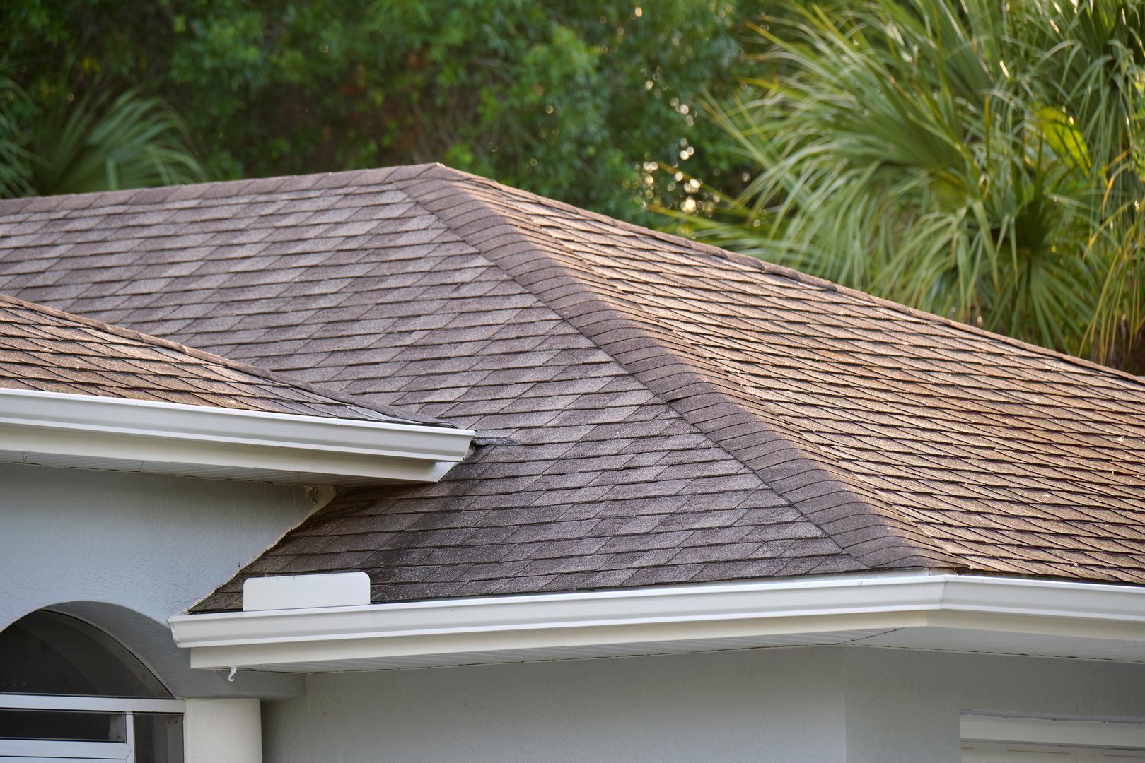 Closeup of house roof top covered with asphalt or bitumen shingles. Waterproofing of new building.