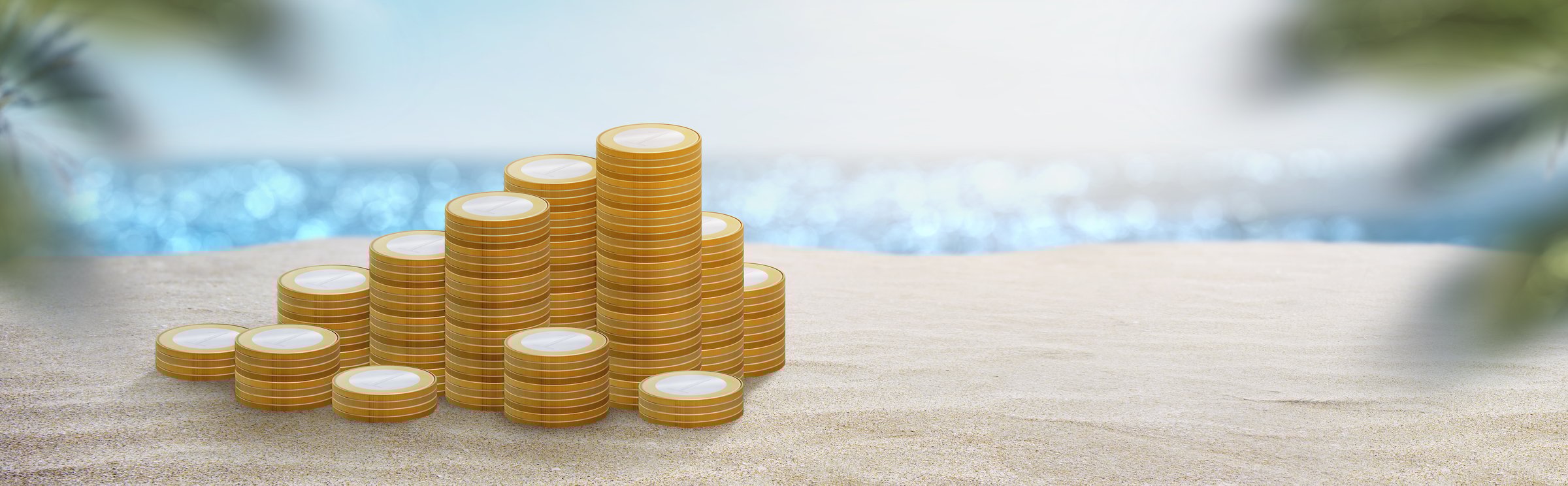 stack of coins on the sand of a beach in summer - savings concept