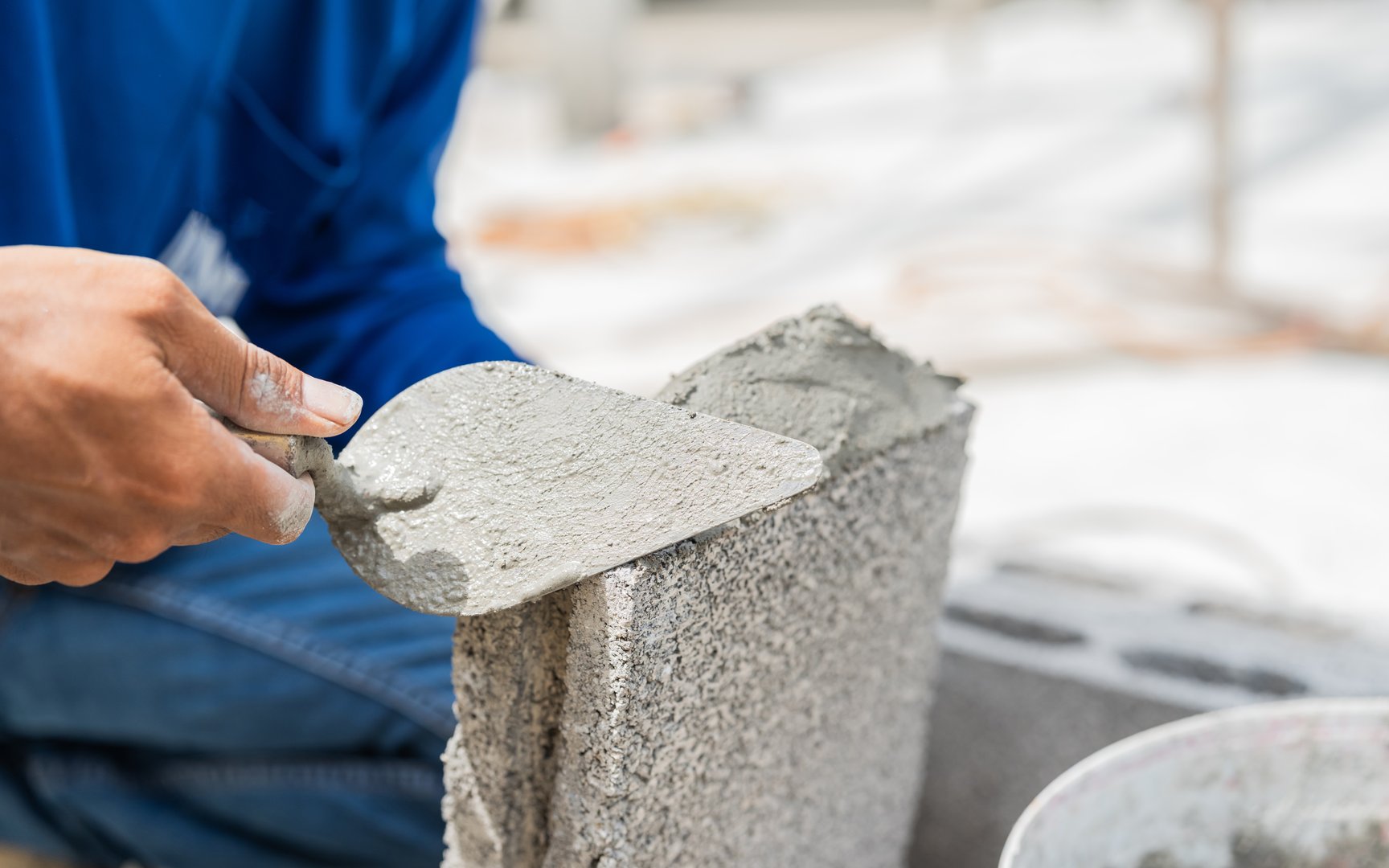 Hand worker masonry make concrete wall by cement block and plaster at construction site