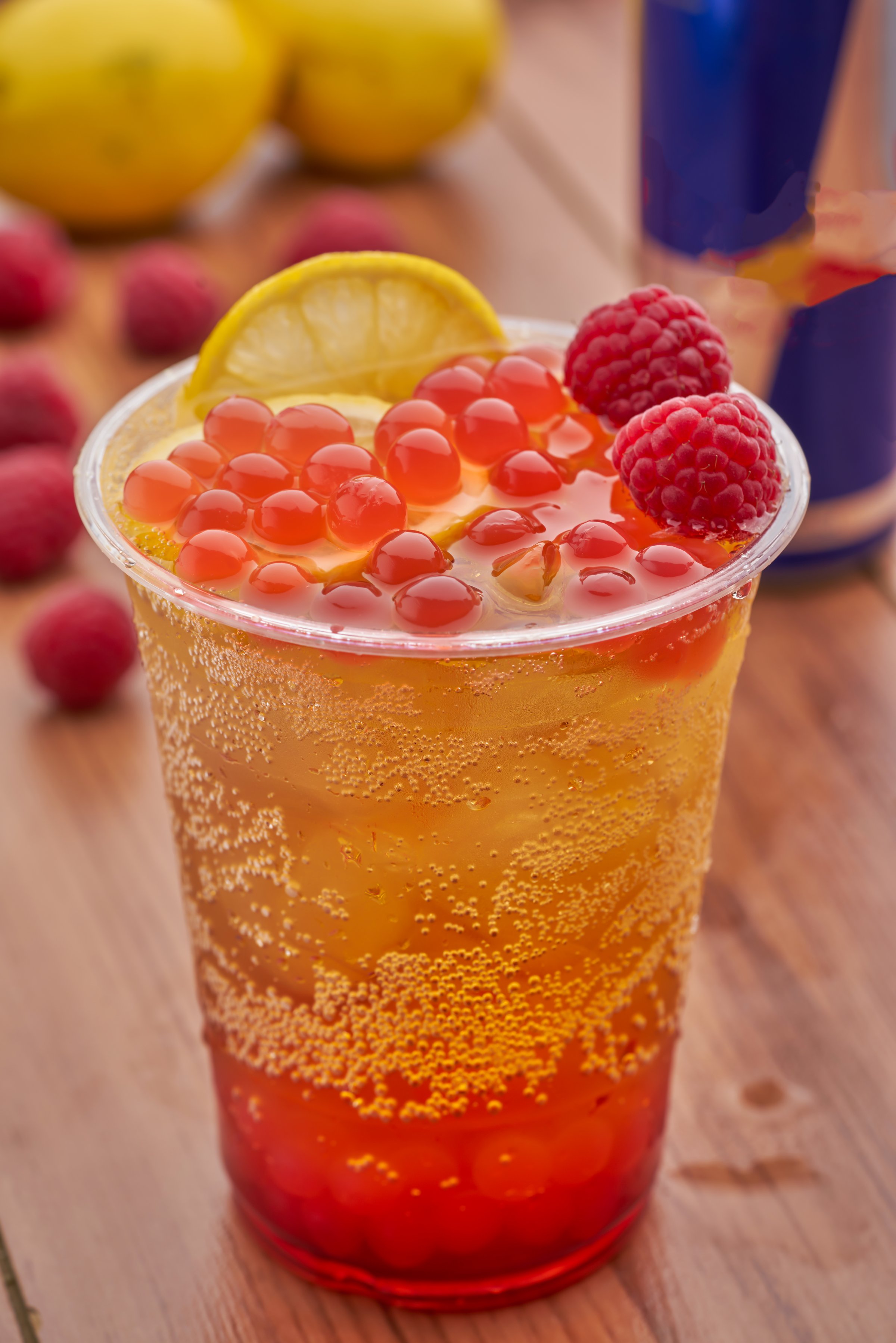 Raspberry Mojito with Lemon Boba with Popping Pearls in plastic cup closeup side view of summer drink