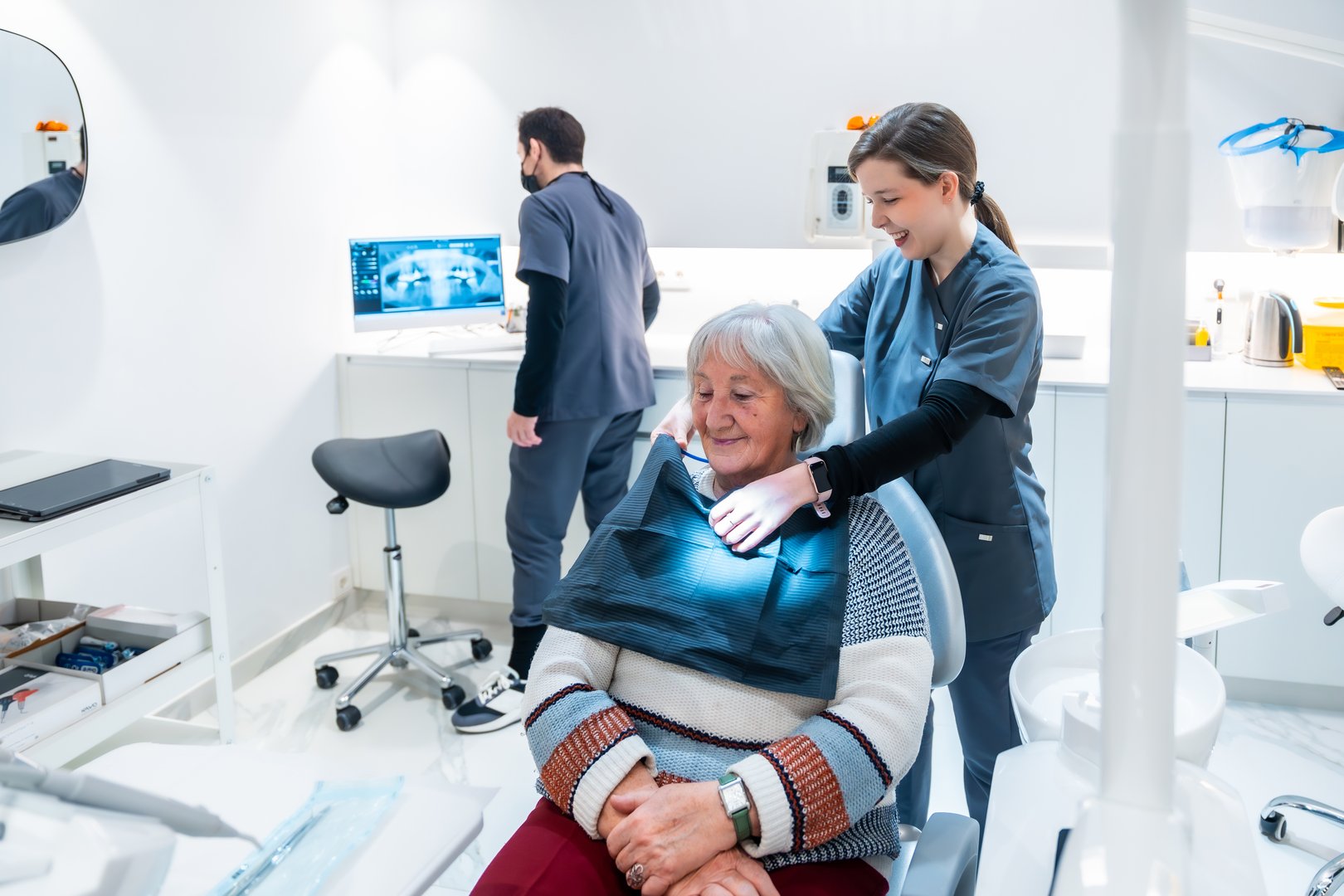 Senior woman sitting in dentist chair, preparing for a check-up with a friendly dentist in a modern dental clinic