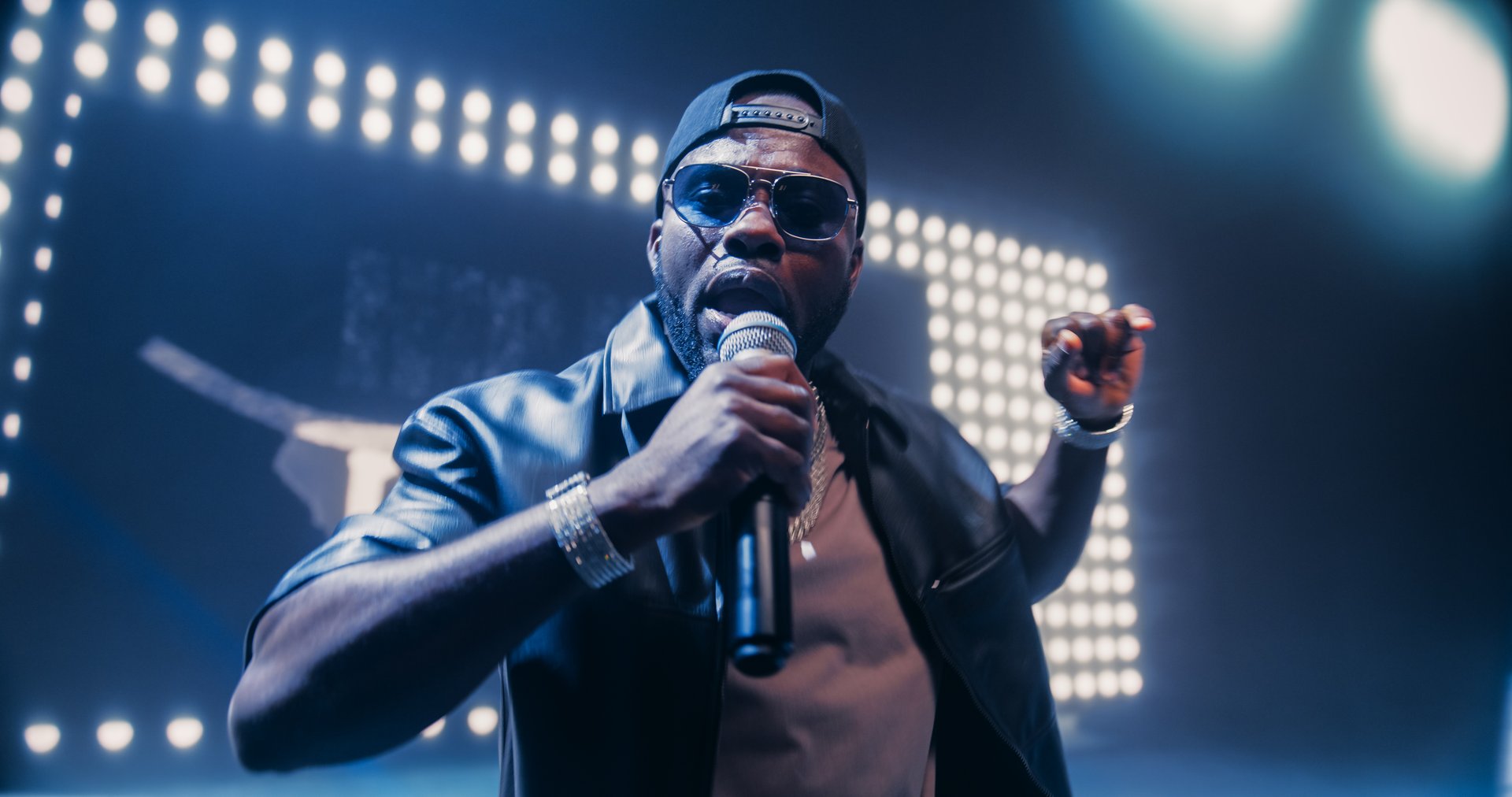 Creative Rap Artist Performing a Hit Song on Stage with a Striking Female Dancer, Inspiring a Large Audience in a Colorful Neon Concert Setting with Cinematic Lighting and Animated LED Screen