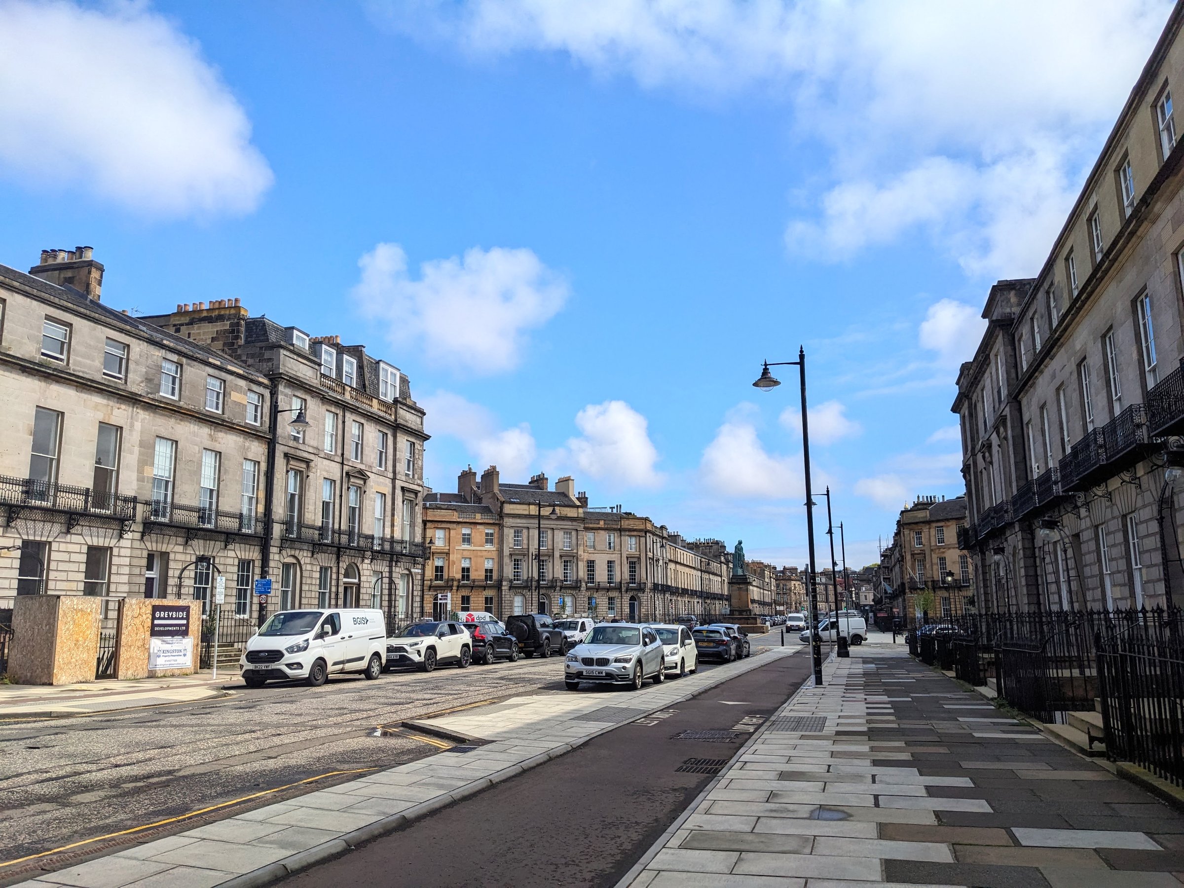 Edinburgh, Scotland - July 16 2025: A wide Melville Street featuring classic Georgian architecture, parked cars, and a broad pavement leading through the historic New Town on a bright day