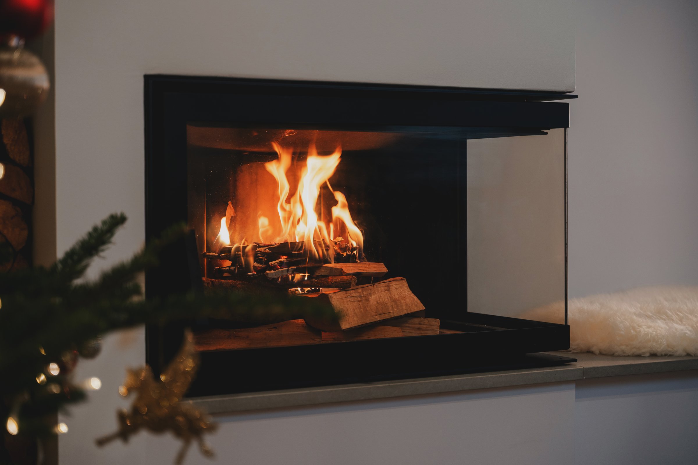 Burning Firewood in Modern Glass Fireplace for Cozy Winter Ambiance.