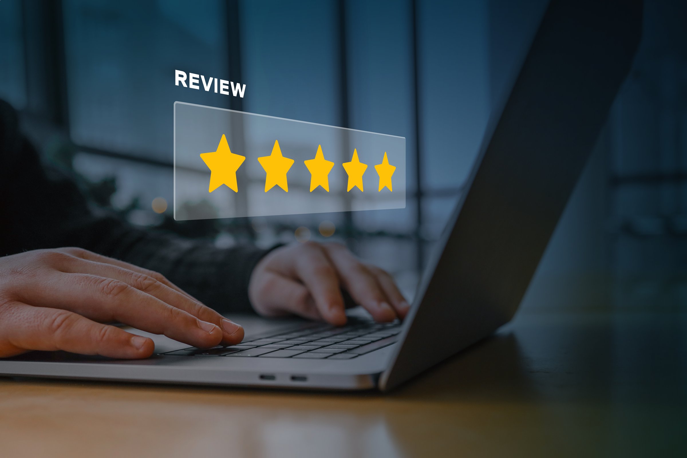 A person using a laptop with a digital overlay of a five-star rating and the word 'review.' Concept of customer feedback, online reputation, business rating, and digital marketing strategy.
