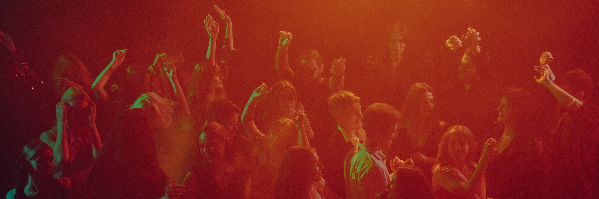 Red light glow surrounding New Year party crowd in festive haze. Concept of event promotion, nightlife visuals, brand celebration, and emotional unity. Banner