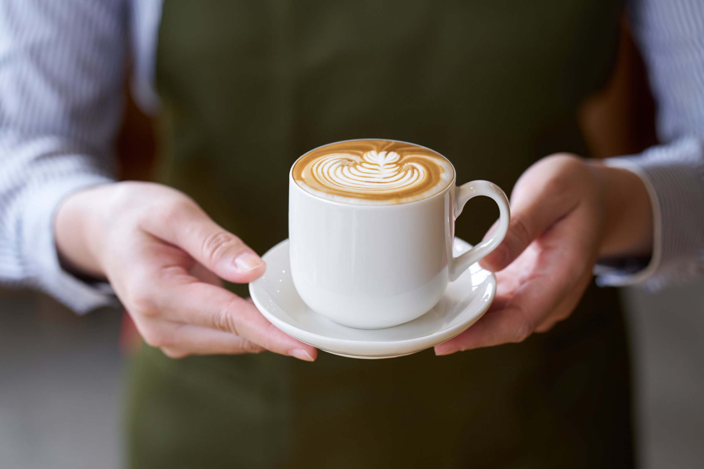Hand of a cafe clerk offering coffee